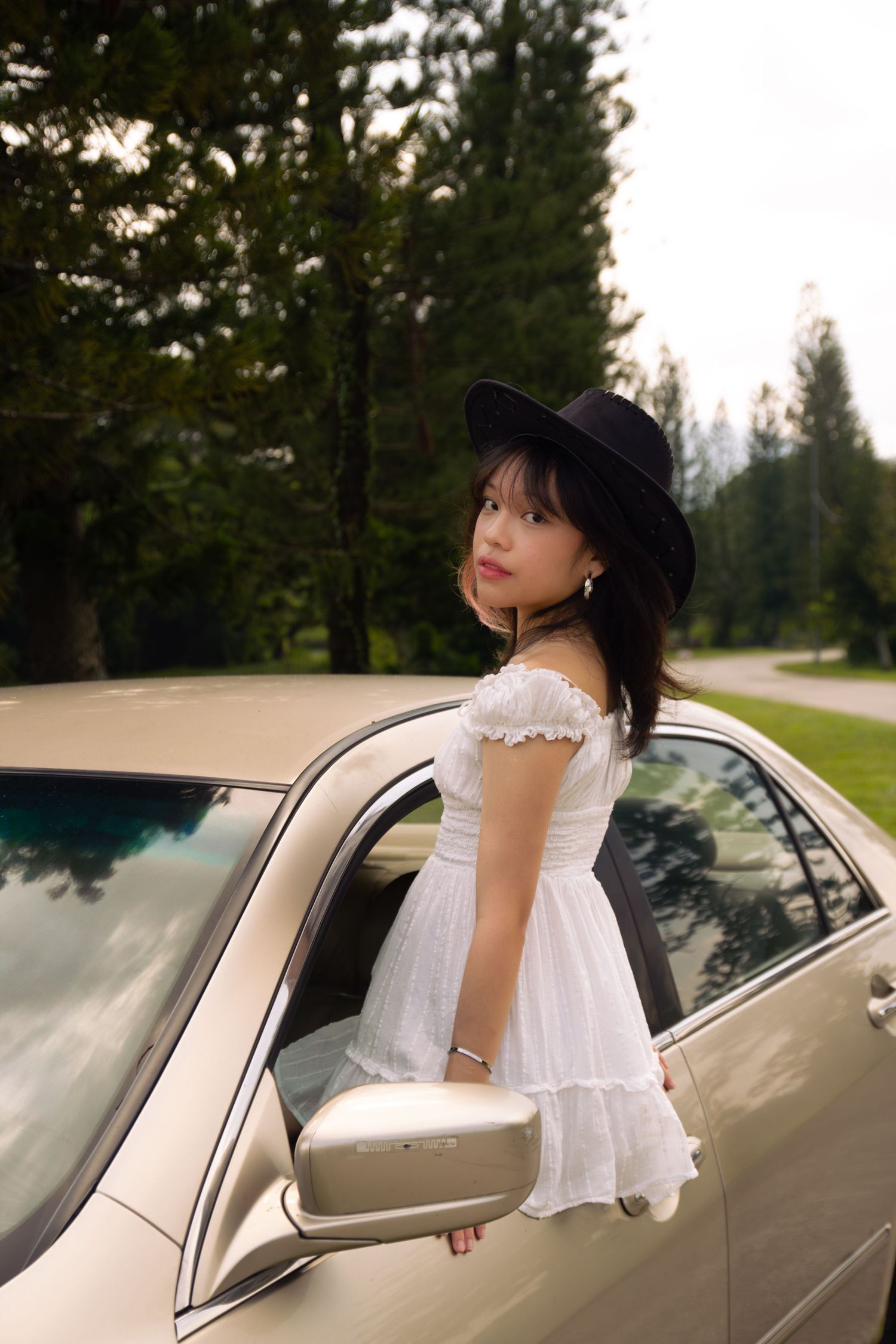 cowgirl with half her body out the window of her car