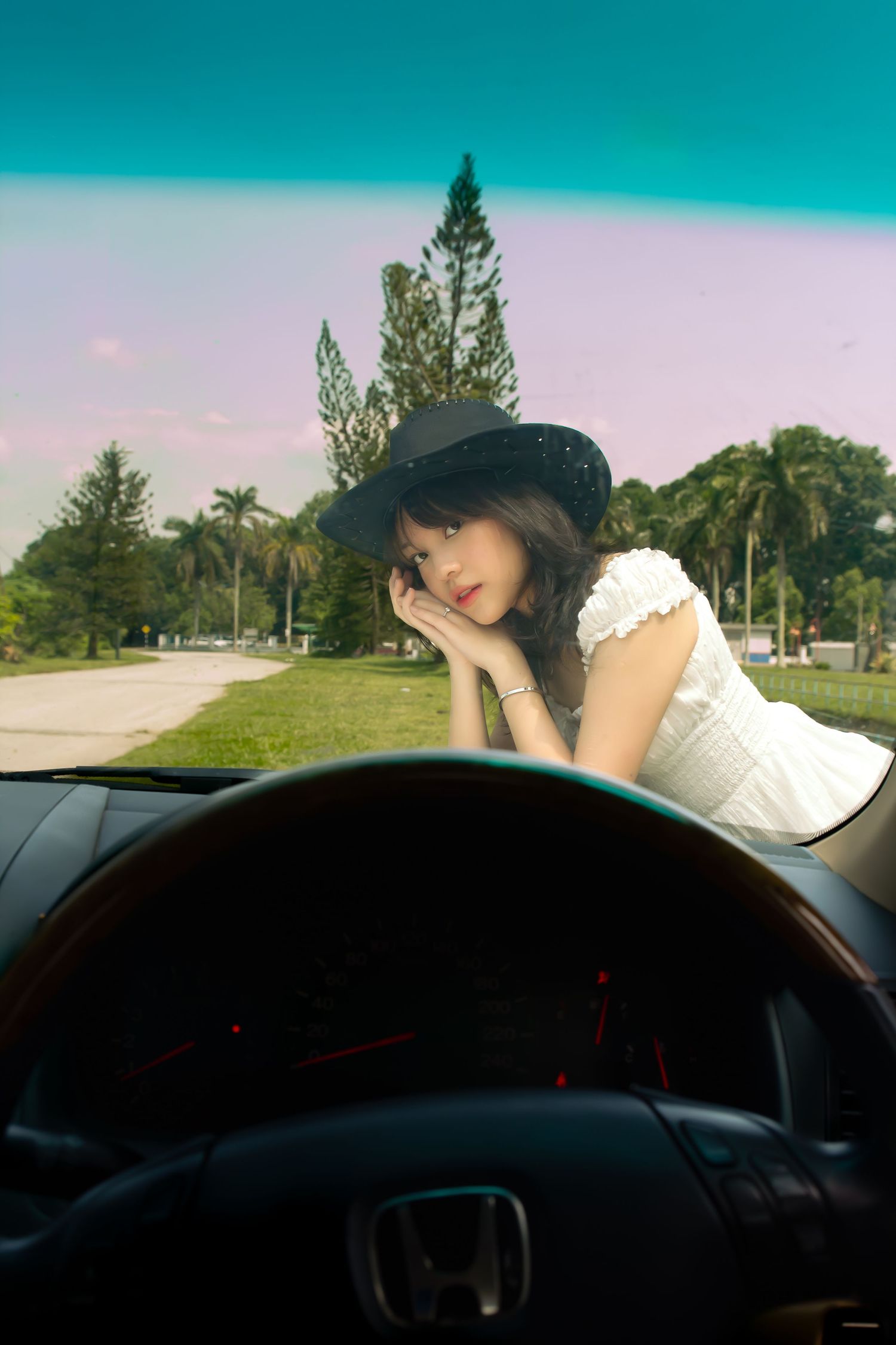 cowgirl in the hood of her car