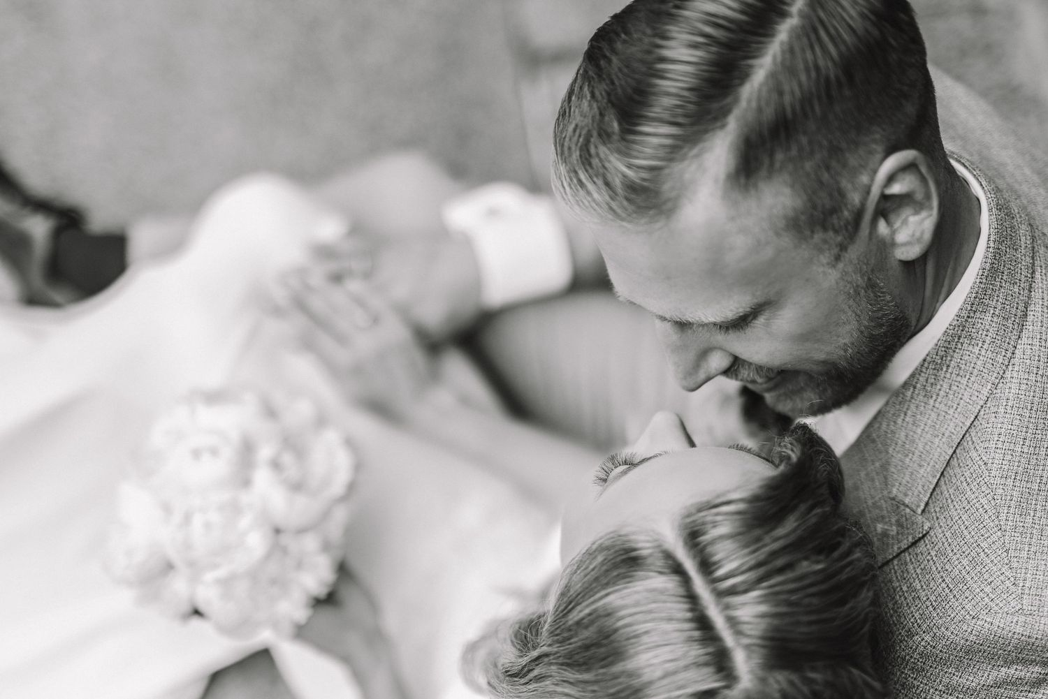 Vestuvių fotografija, kurioje iš viršaus matomi nosimis susiglaudę jaunieji