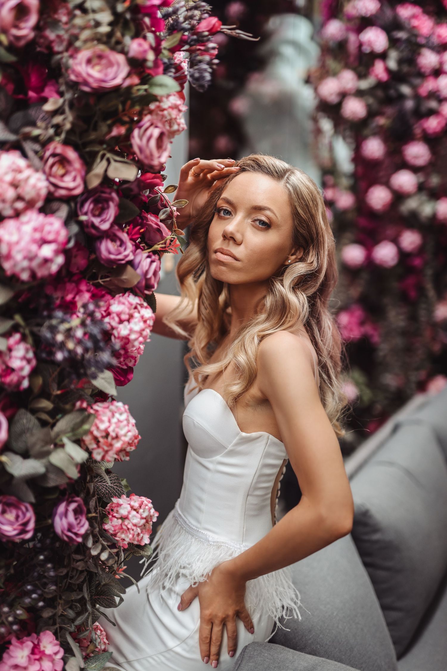 Vestuvių fotografija tarp rožinių gėlių. Mados stiliaus vestuvinė fotografija