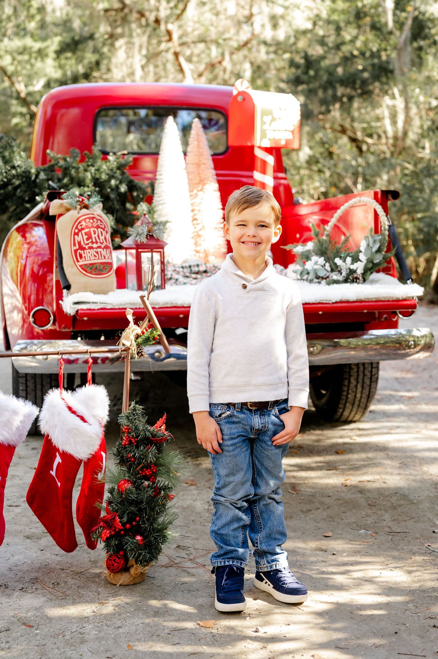 A series of holiday photos featuring a red vintage truck decorated with Christmas wreaths and white trees in an outdoor setting.