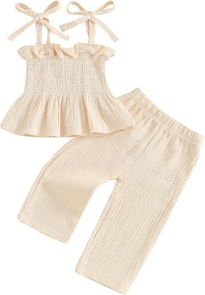 Cream colored smocked ruffle top and wide leg pants set with shoulder tie straps.