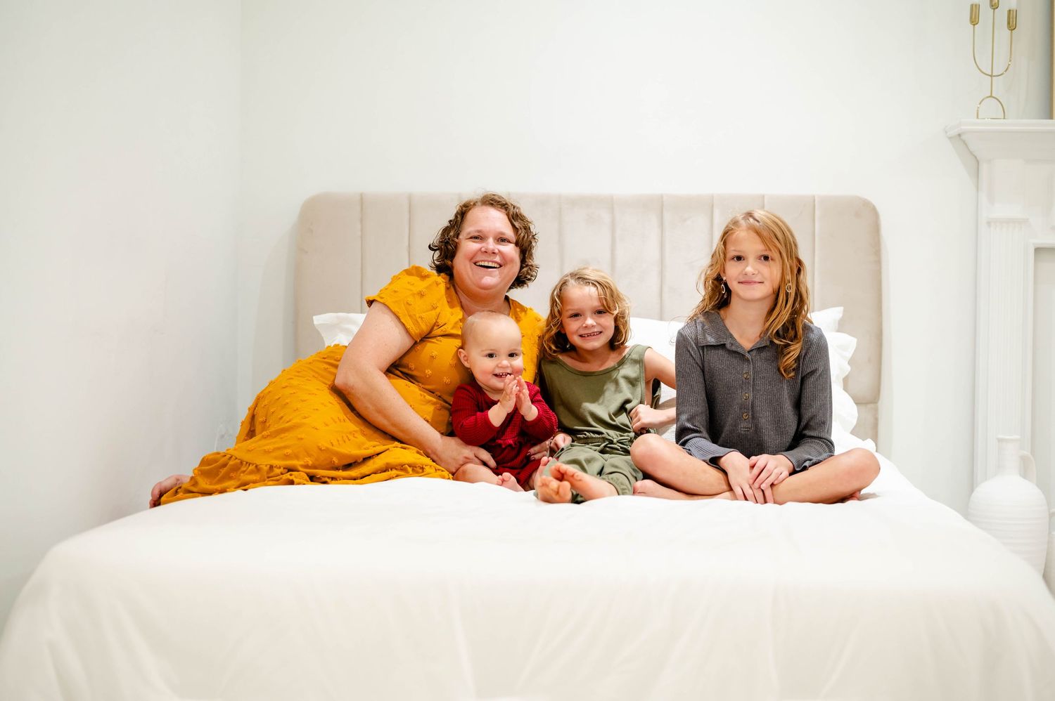 Jessica's Jacksonville Family lounging together on white bed during casual lifestyle photoshoot.