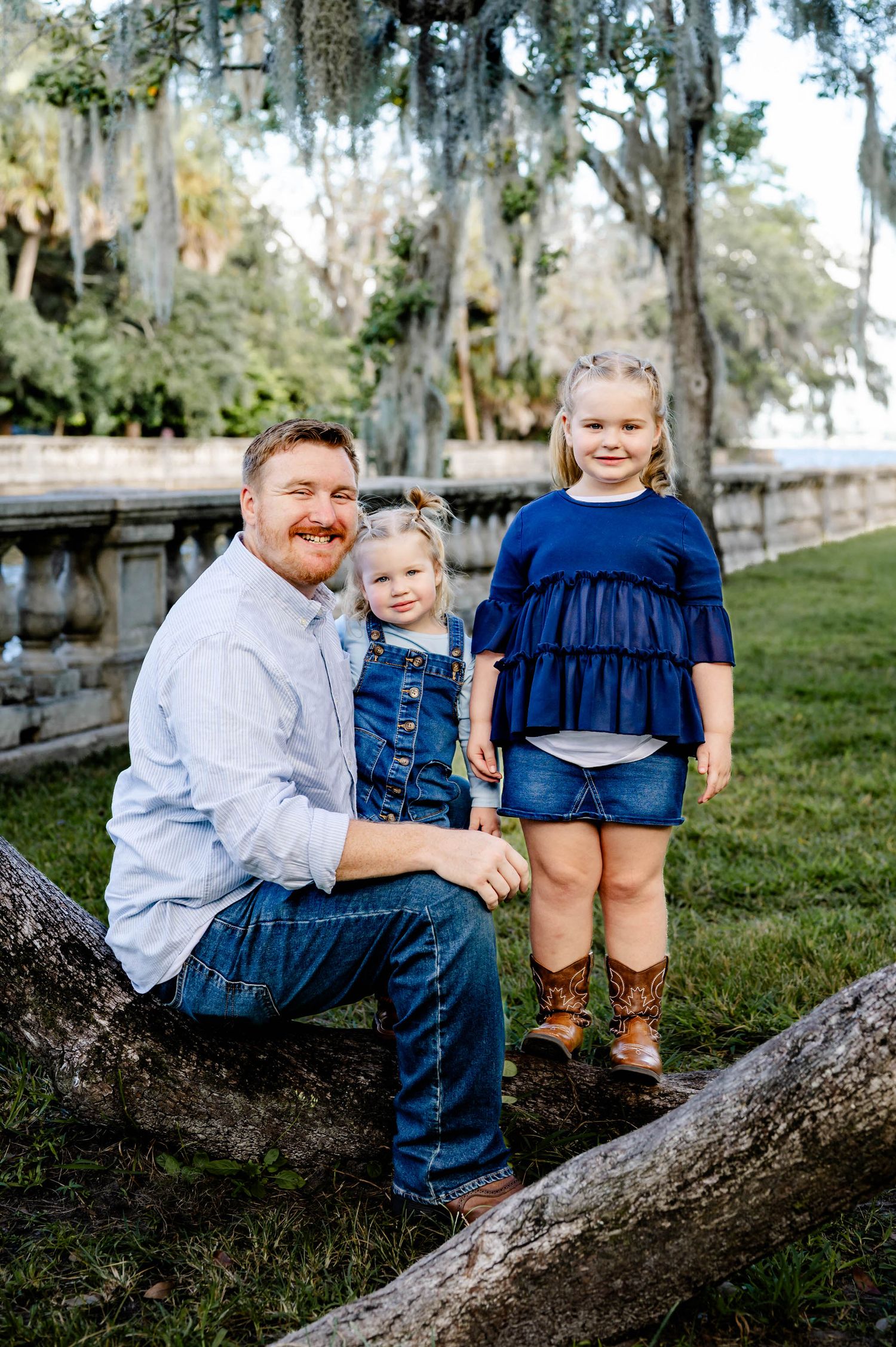 Three candid outdoor family photos show playful moments together on a large tree branch with Spanish moss in the background.