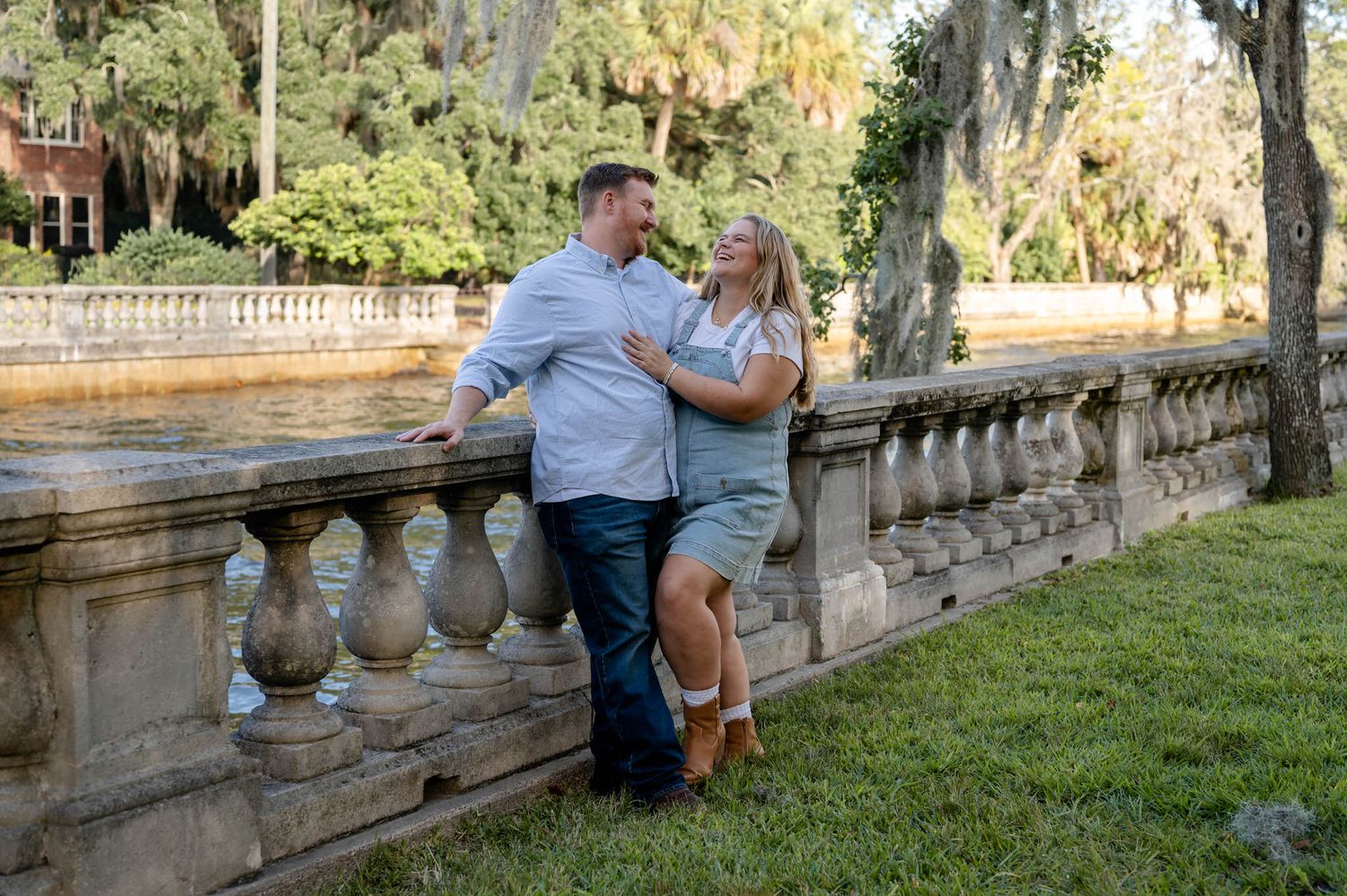 A couple sits together on stone steps surrounded by lush greenery in a romantic outdoor setting at a spring mini session in jacksonville, fl
