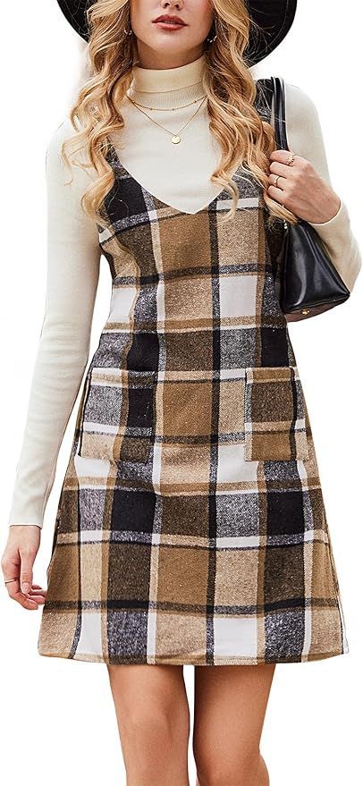 Plaid pinafore dress styled with cream turtleneck and black hat.