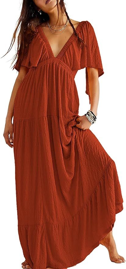 Flowy rust-colored maxi dress with v-neck and flutter sleeves in casual boho style featuring tiered ruffled design.