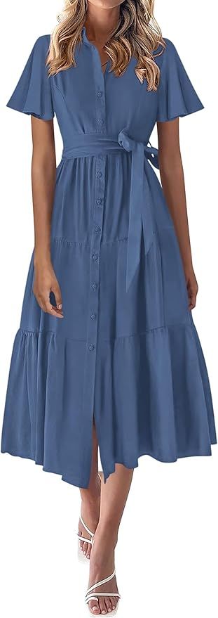 Elegant blue midi dress with flutter sleeves, button-front design, tie waist and tiered skirt paired with white sandals.