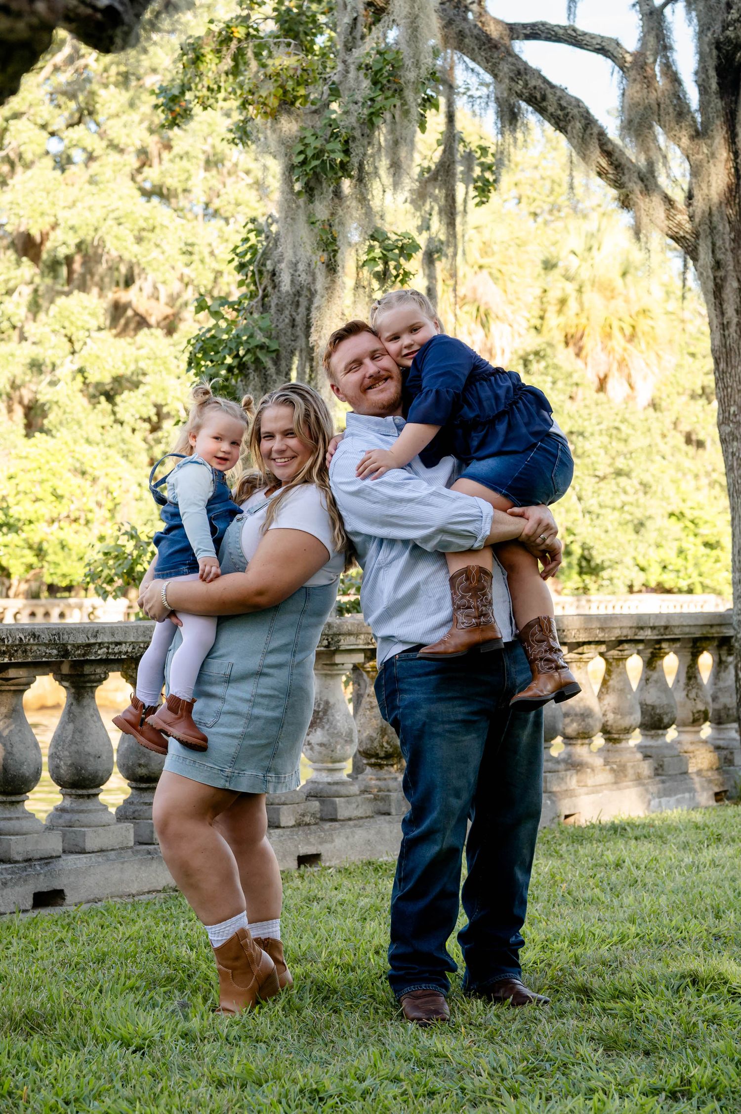 A playful photo showing a family having fun together in a garden setting with stone balustrades at a spring mini session in jacksonville, fl