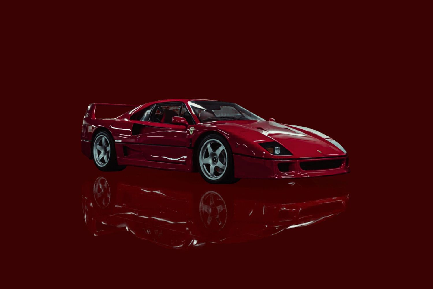 A sleek red Ferrari F40 supercar on a dark red background with a reflective surface below.