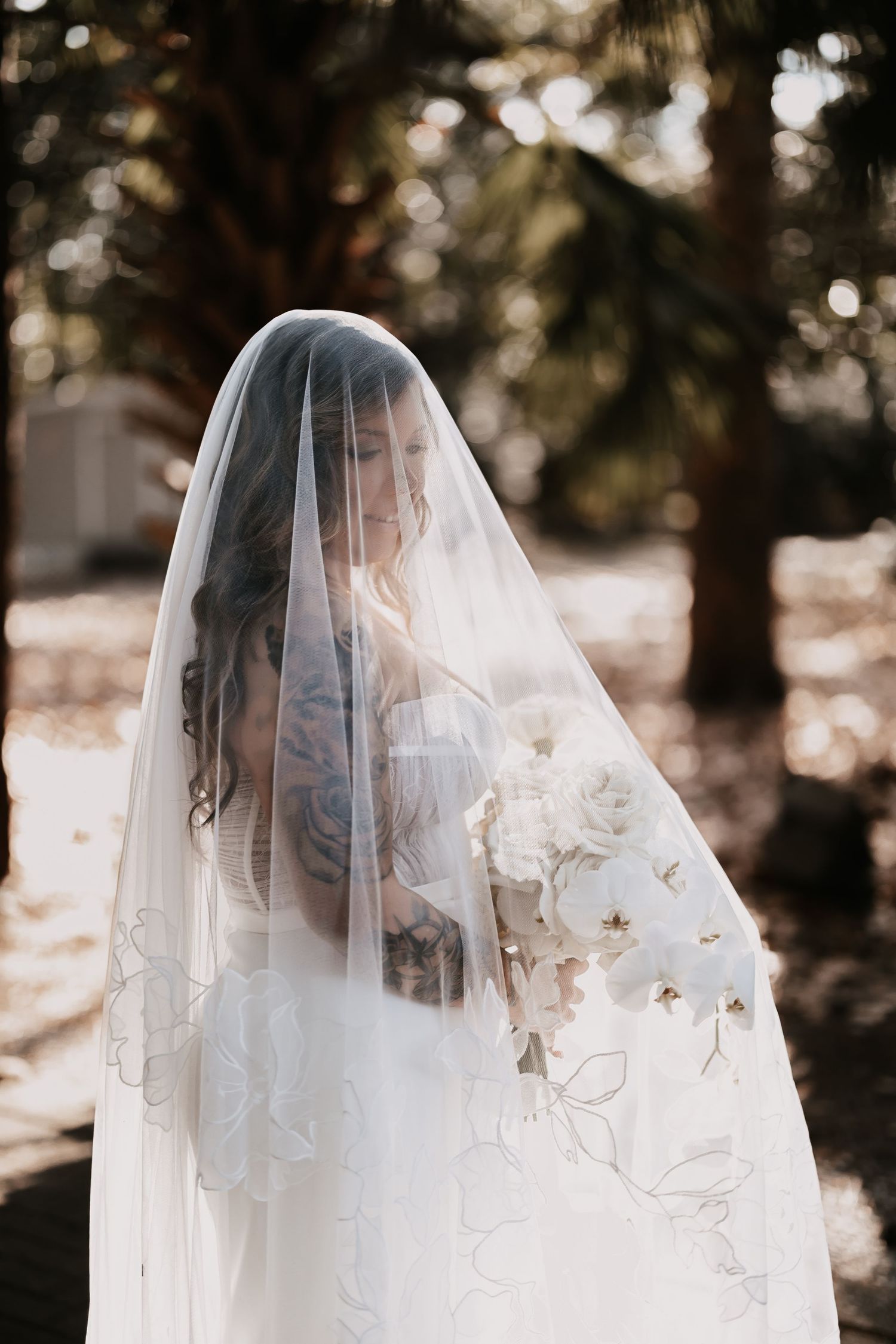 A delicate bridal veil with intricate lace details creates an ethereal silhouette against a dreamy bokeh background.