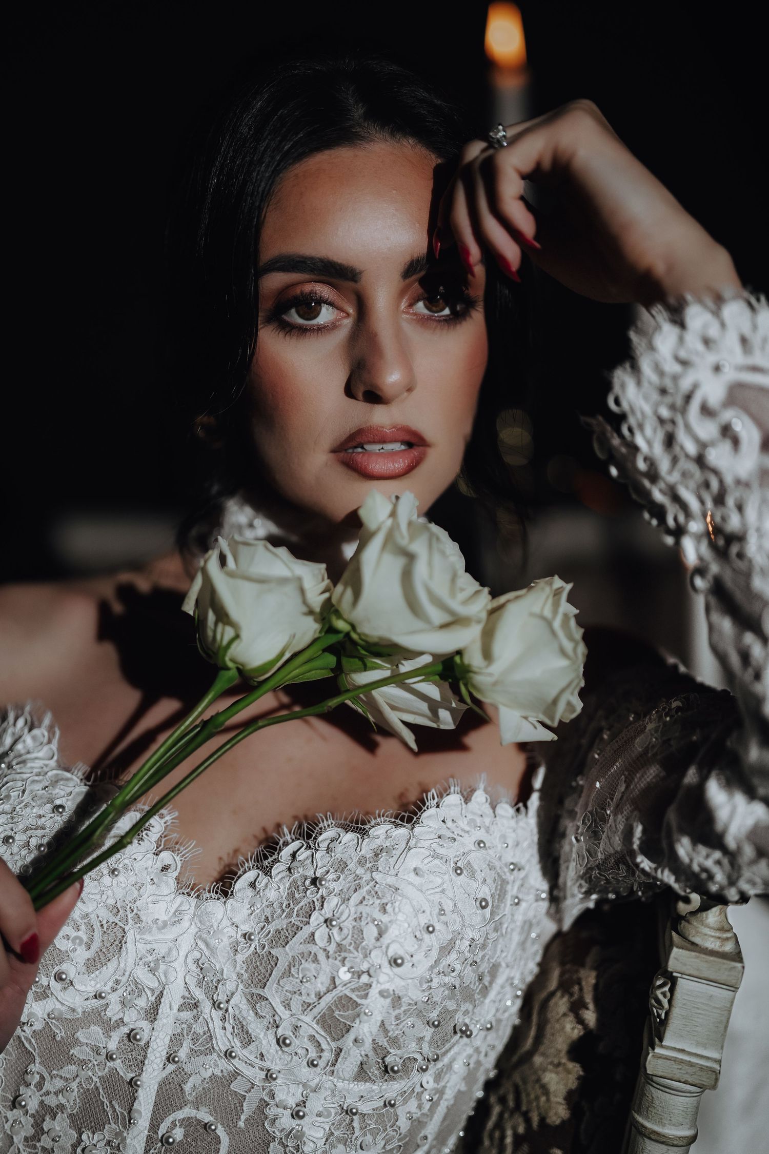 Artistic bridal portrait with white roses and lace details captured in dramatic moody lighting.
The Howey Mansion