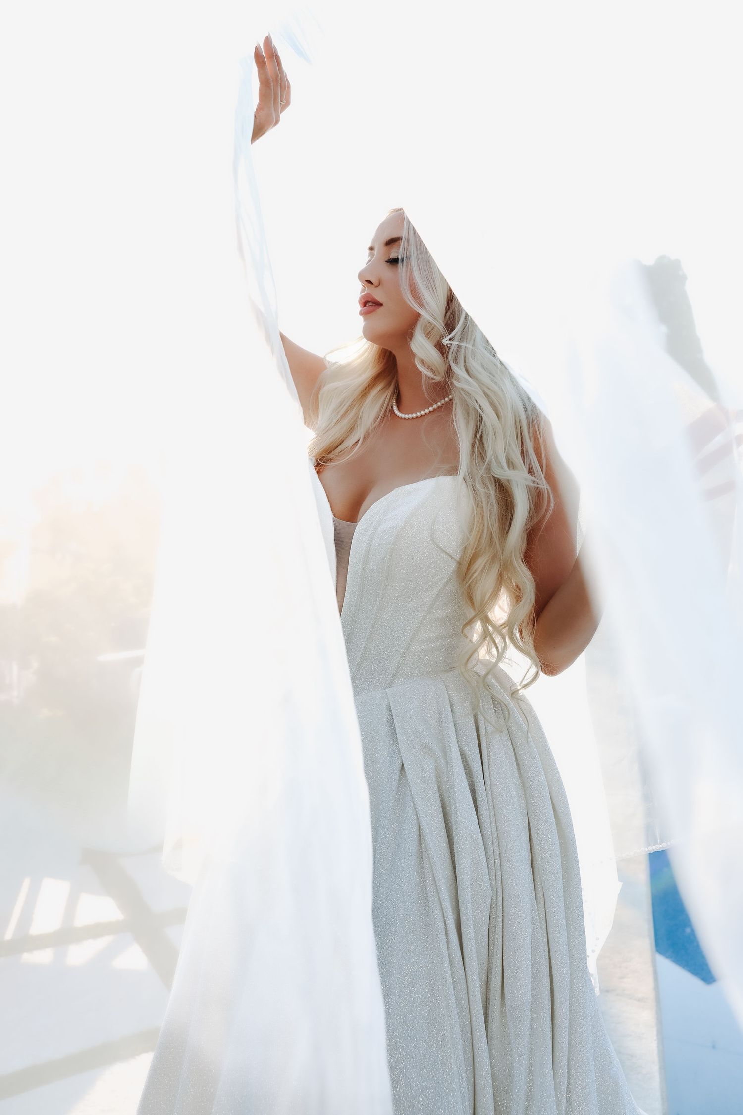 Woman in white dress twirls gracefully against bright background in four sequential motion shots.