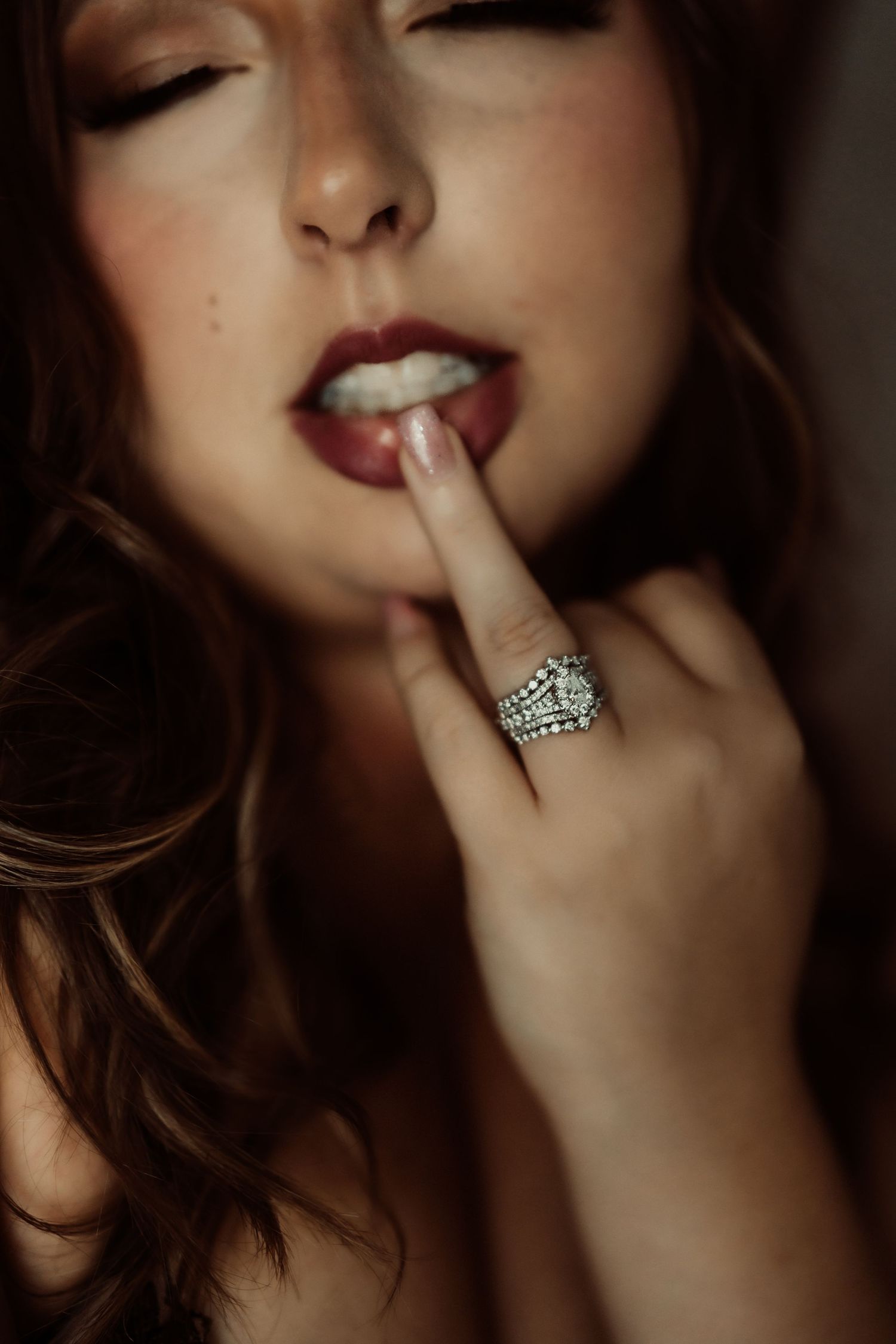 Close up artistic photo series showing red lipstick, jewelry and sensual poses in dark moody lighting.