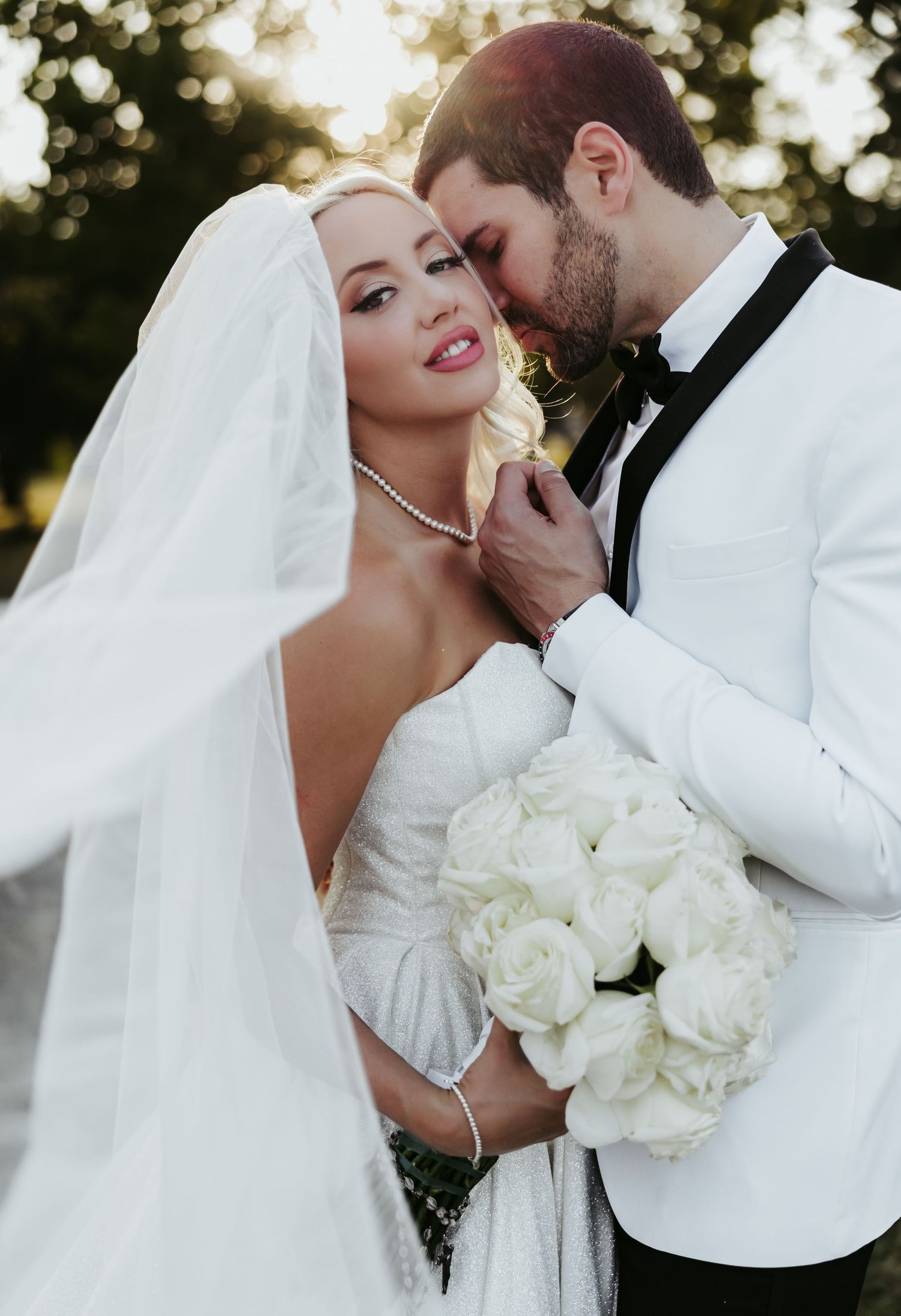 A romantic wedding photoshoot sequence showing tender moments between newlyweds with white florals and elegant attire.
The Elia Event Venue