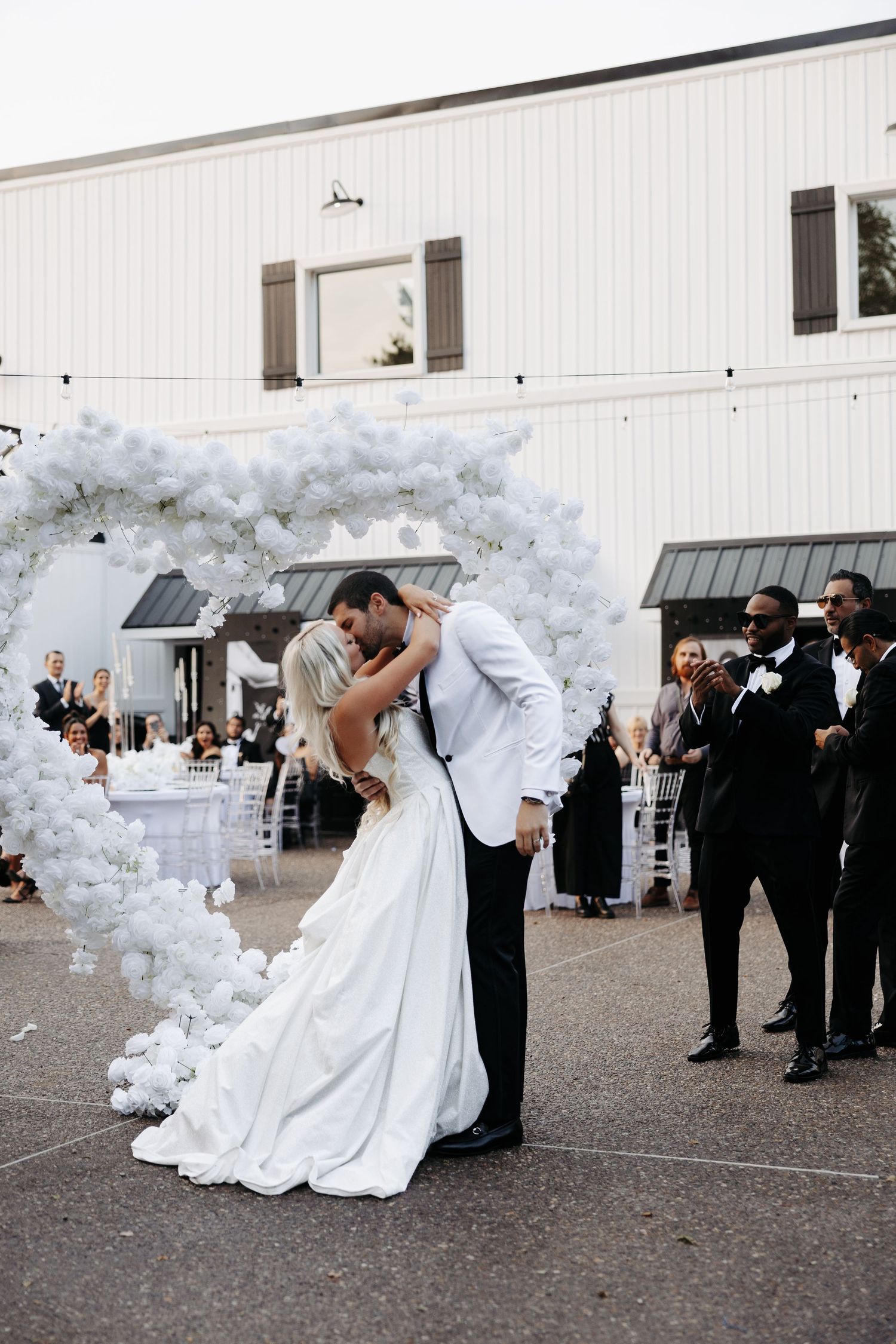A romantic wedding sequence shows a couple in a dip pose with white balloon arch decorations and guests watching.
The Hillside Estate