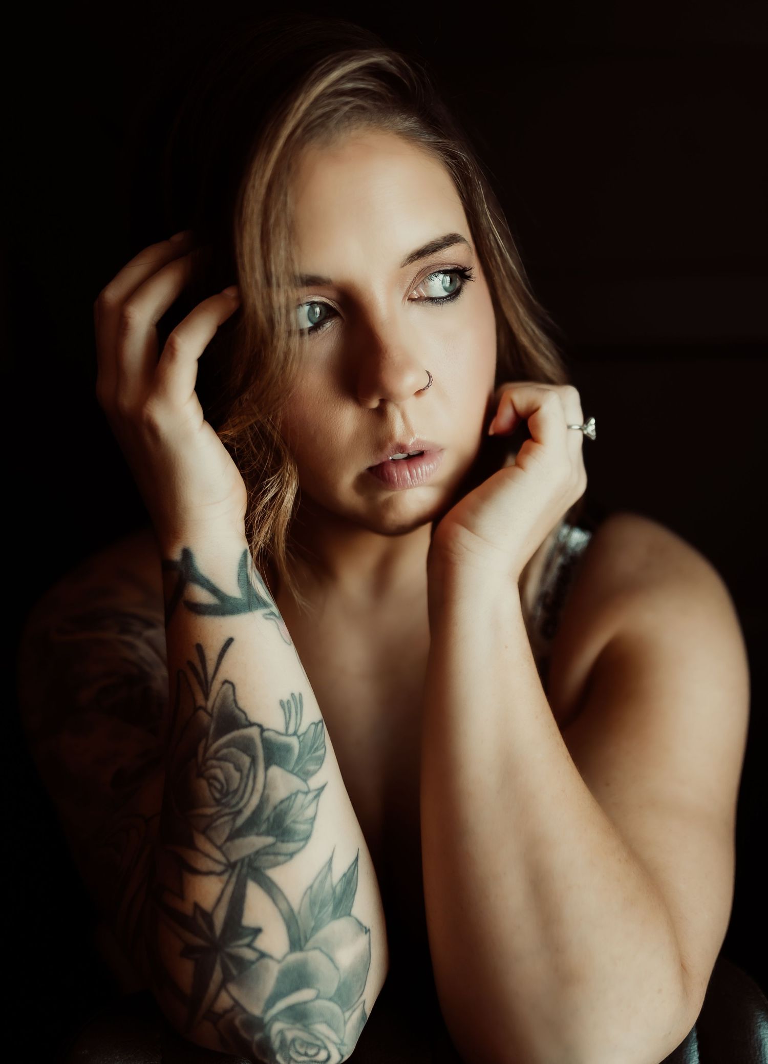 Artistic portrait series showing a woman's face and floral arm tattoo in dramatic low-key lighting.