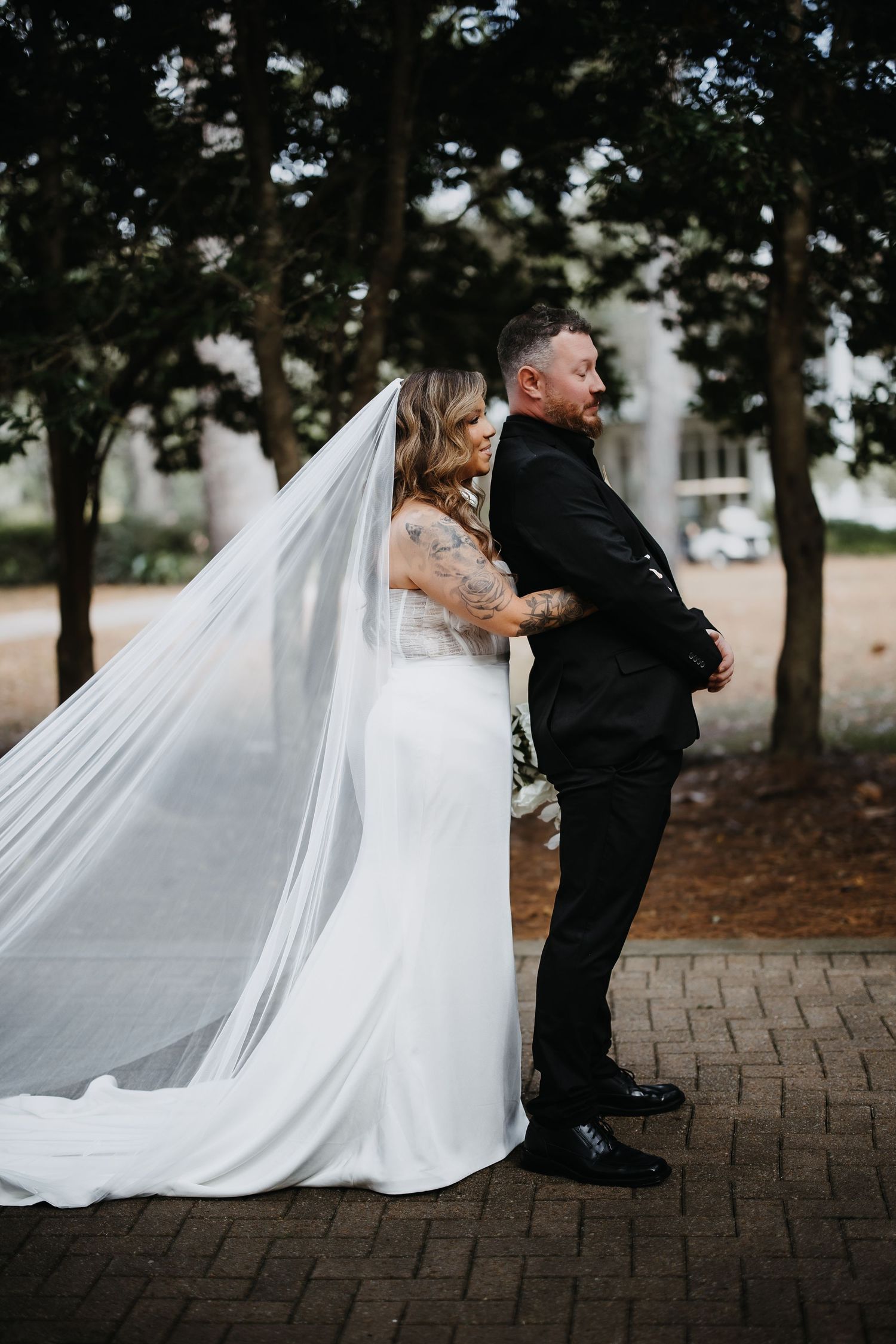 A romantic wedding sequence shows a couple in formal attire dancing playfully on brick pavement as a white veil flows behind them.