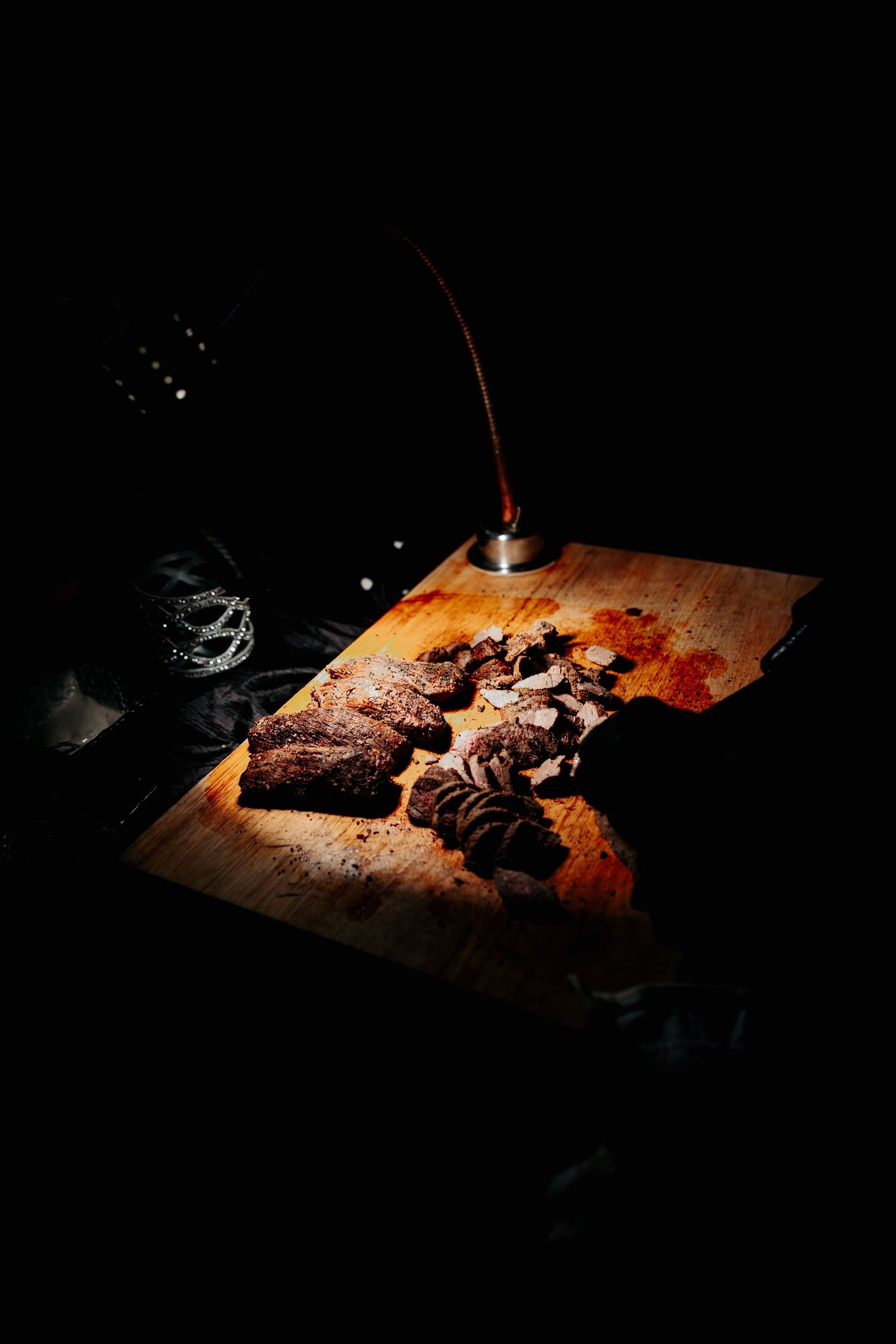 Dark moody food photography of sliced meat on wooden cutting board illuminated by dramatic spotlight.
Vizcaya Museum and Gardens