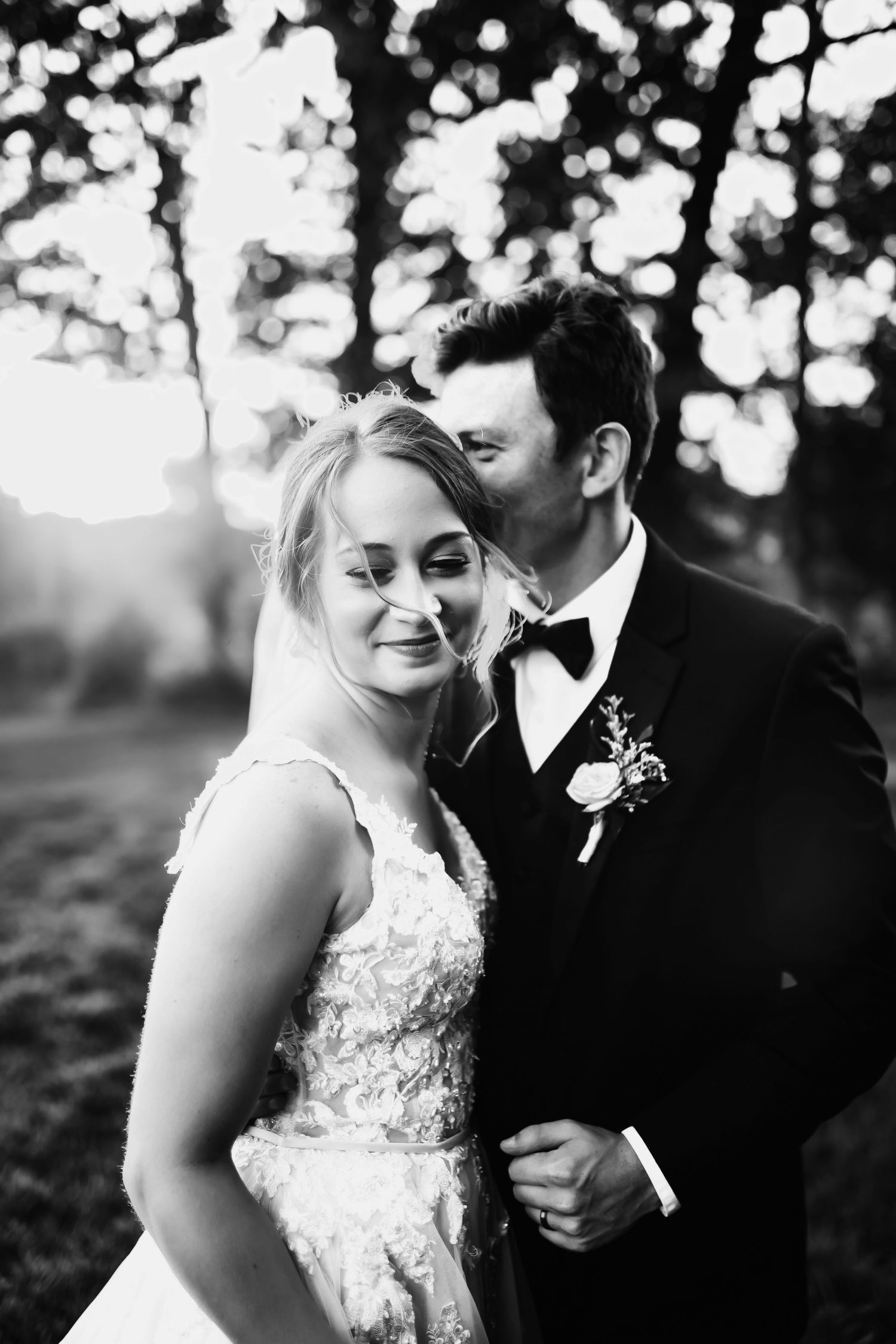 Black and white romantic wedding photo series showing intimate moments between bride and groom in outdoor setting.