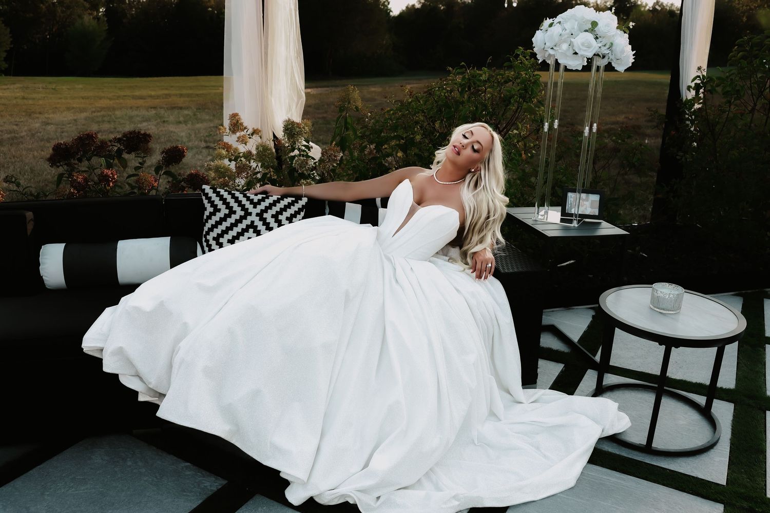 A bride in a flowing white wedding dress lays gracefully across chairs in an elegant indoor setting.
The Elia Event Venue