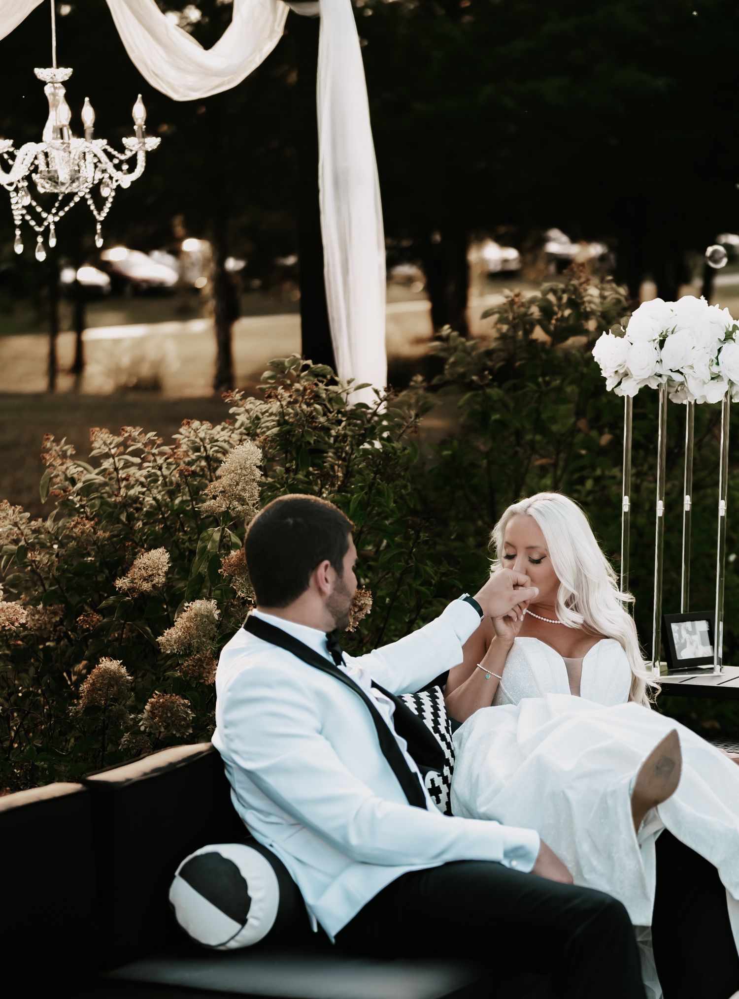 A romantic couple shares tender moments while lounging together on outdoor patio furniture at dusk.
The Elia Event Venue
