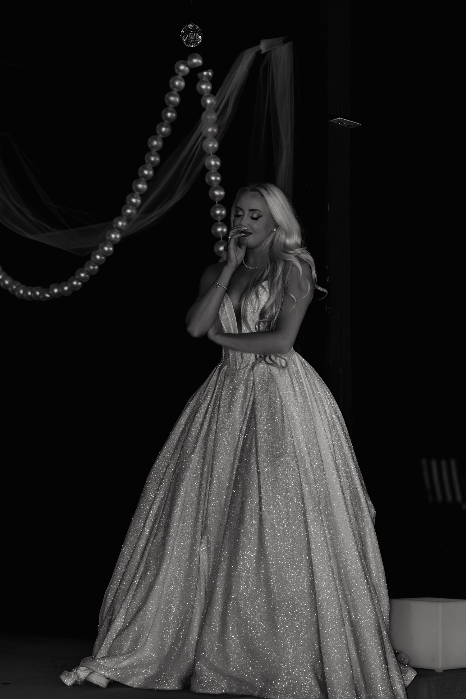Dramatic low-light photos showcase a sparkling ballgown dress at an evening wedding celebration.