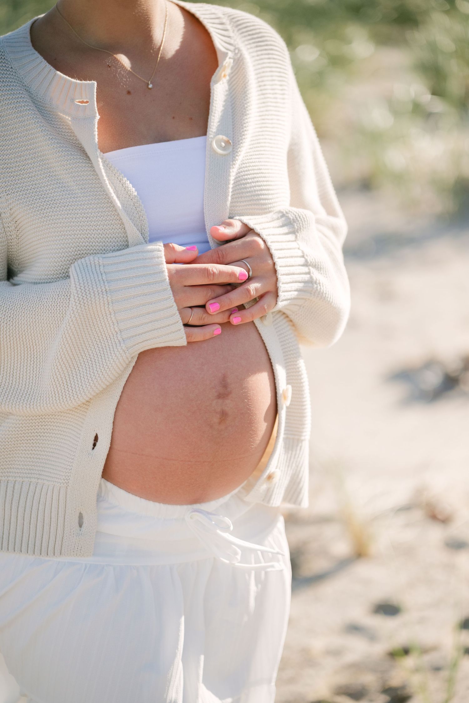An expecting mother holds her bump at Woodlawn Beach State Park