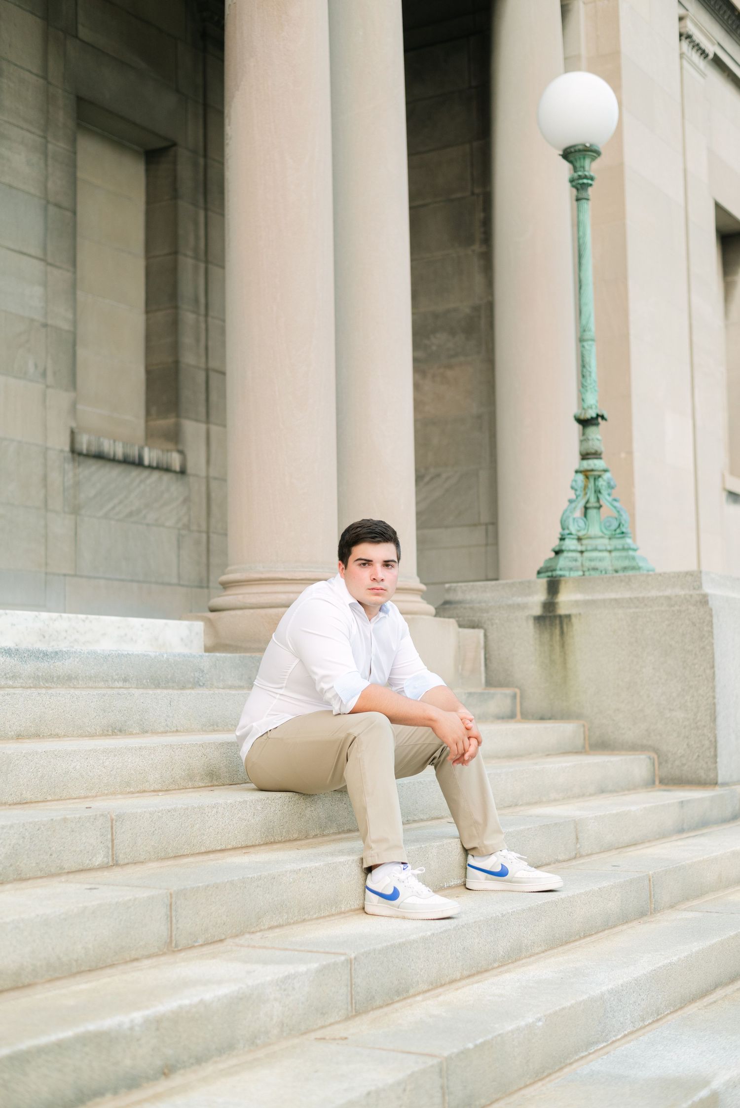 Boy looking serious, leaning on steps at art museum