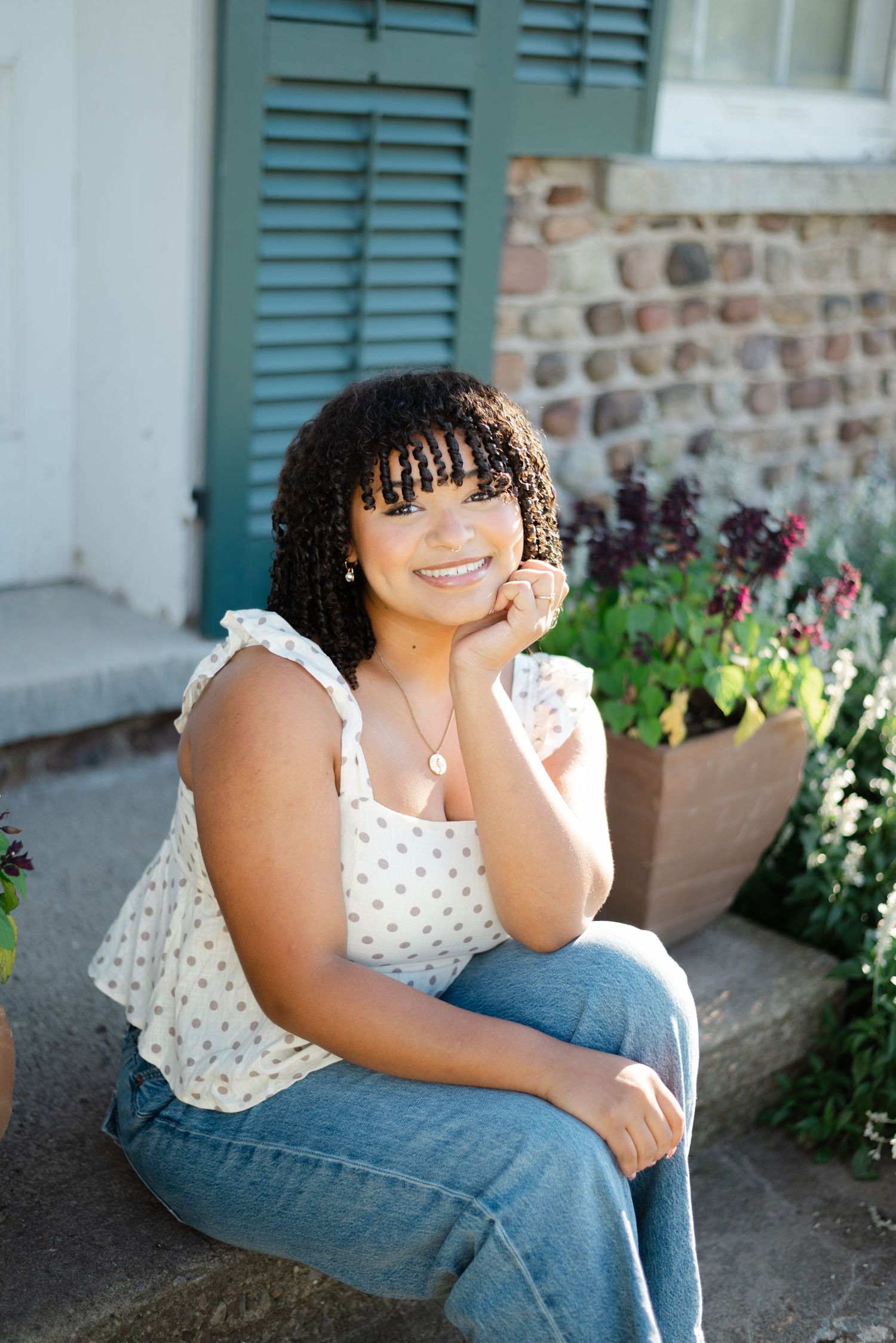A senior leans onto her hands while smiling at Tinker Nature Park in Rochester, NY