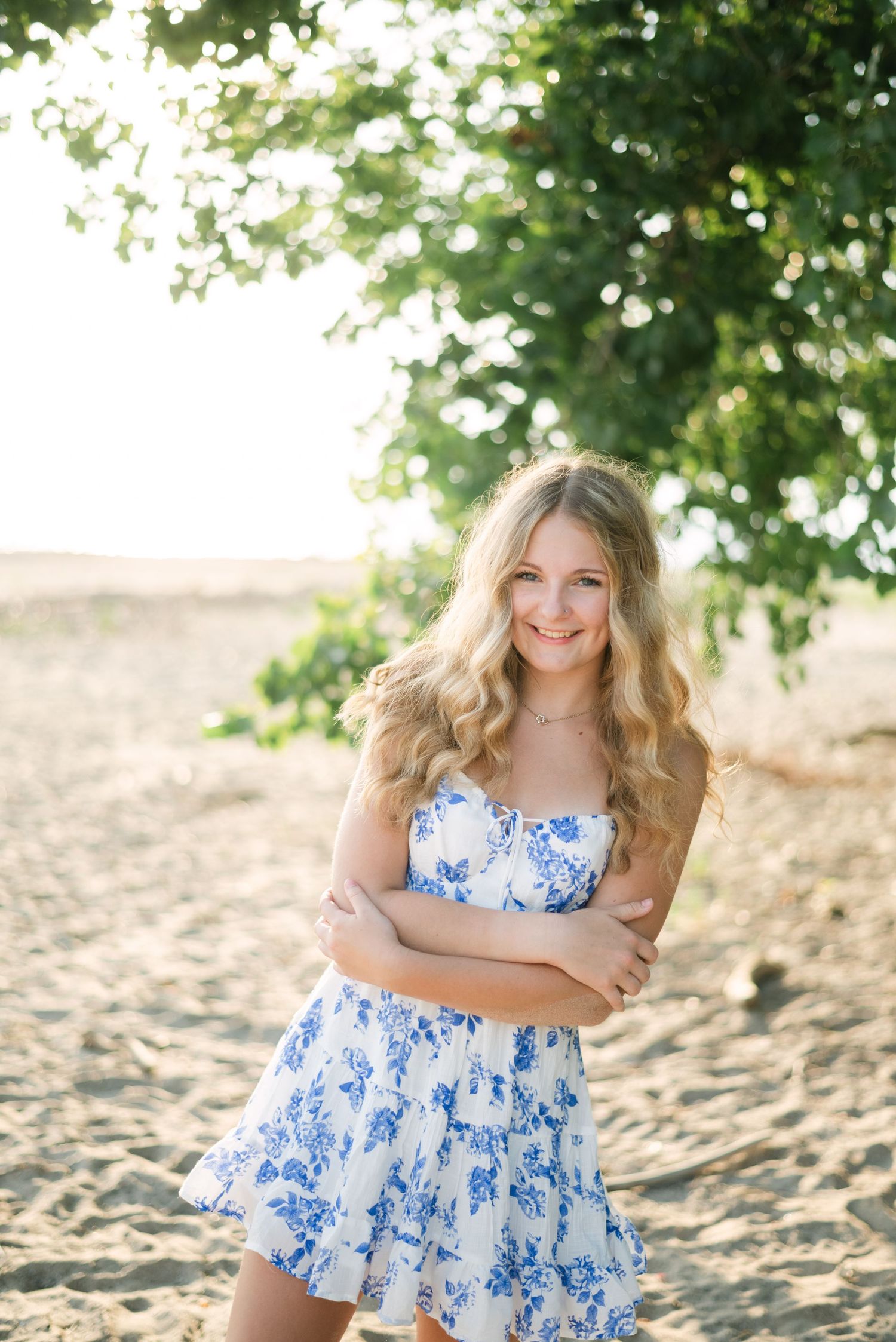 Girl smiling, hugging self on the beach