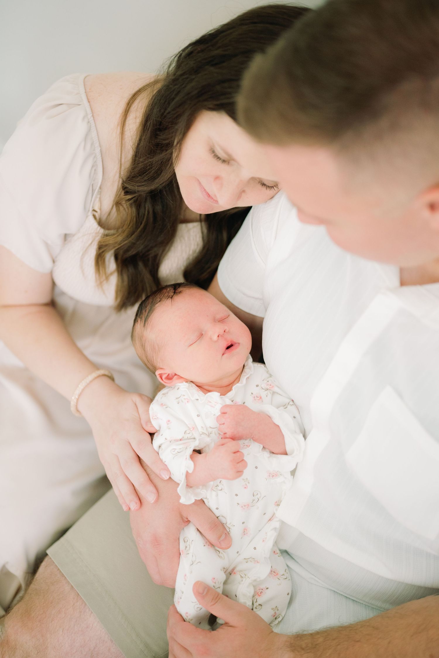 A mom and dad look lovingly down at their new baby, a moment they'll never forget