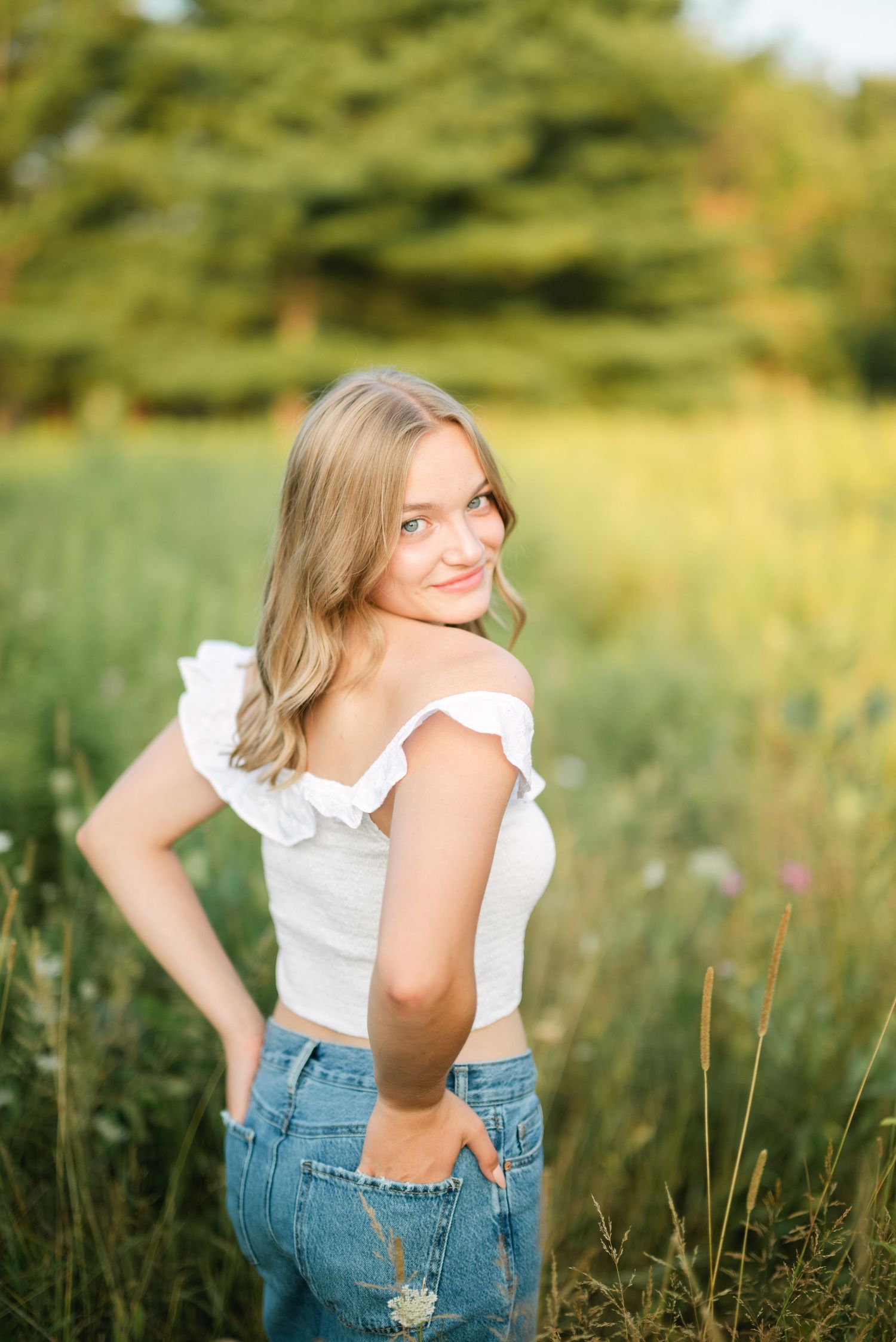 Girl looking over shoulder in a grassy field