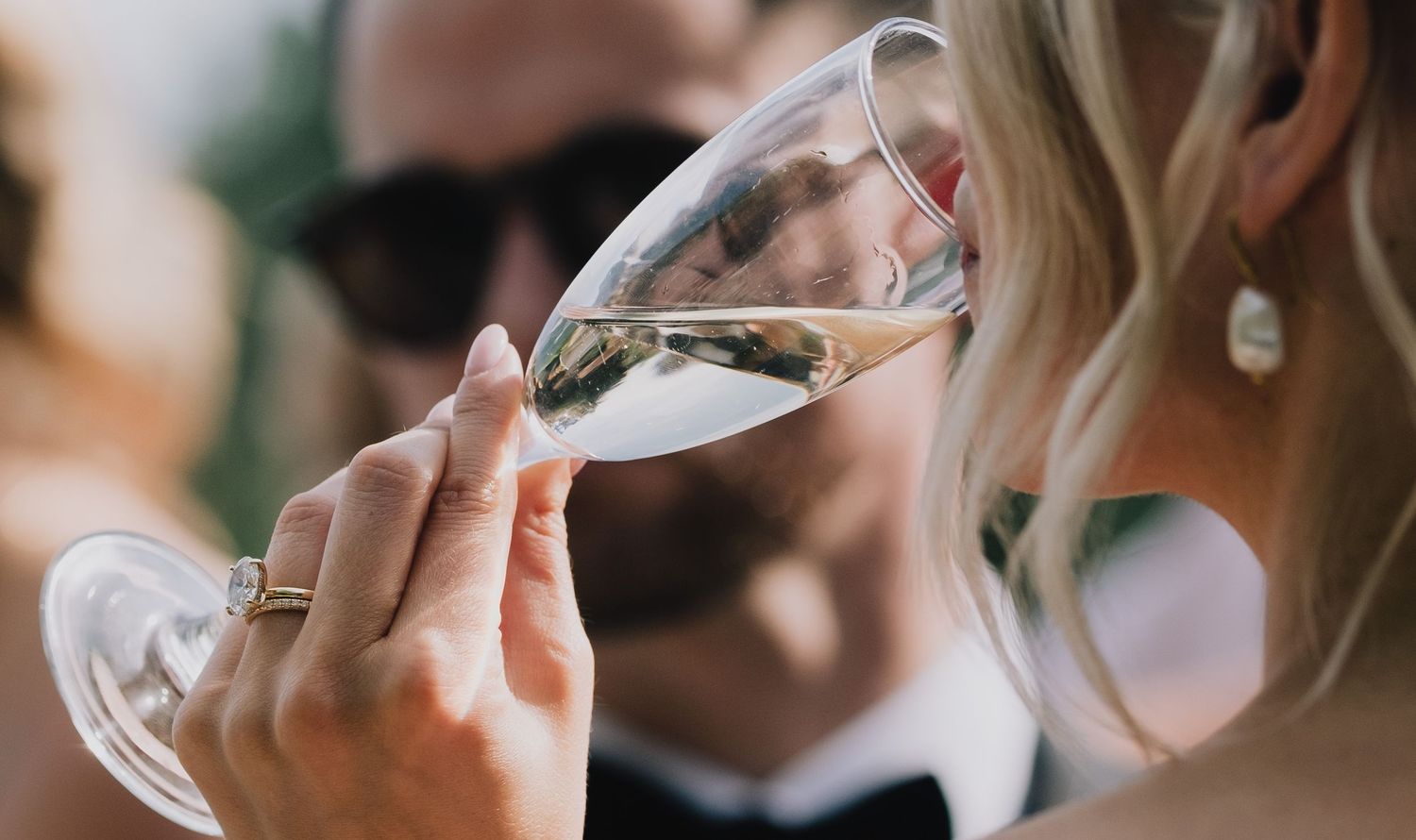Wedding guests raising champagne glasses in an elegant toast during reception.