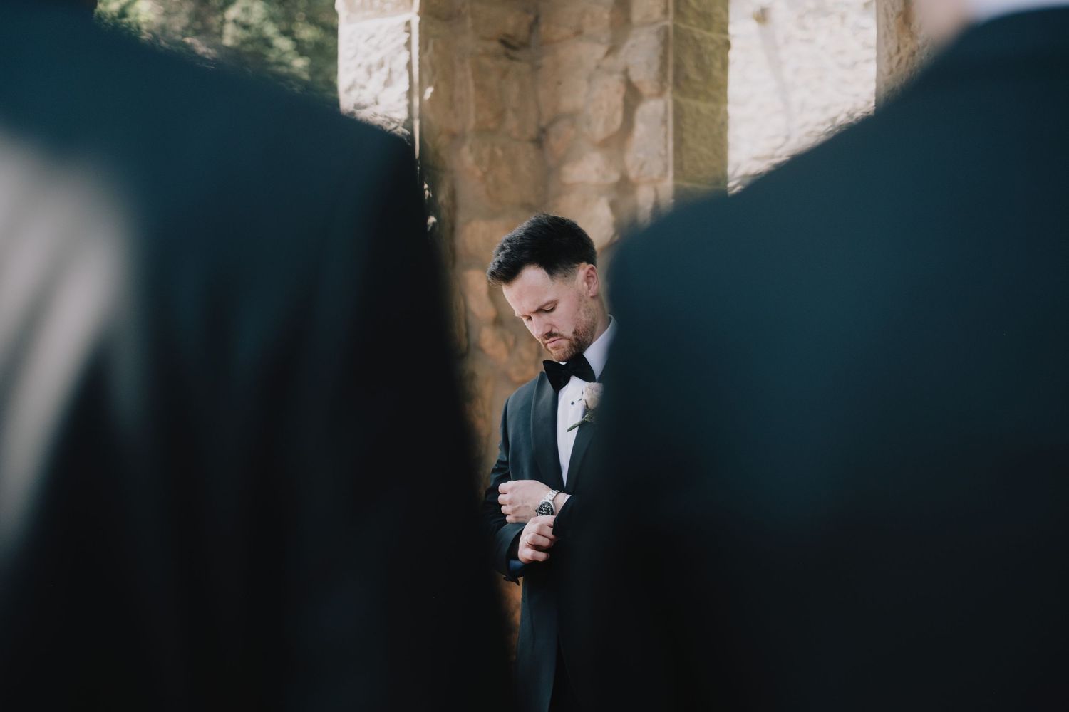 A romantic black and white wedding photo shows a couple embracing in a dimly lit setting.