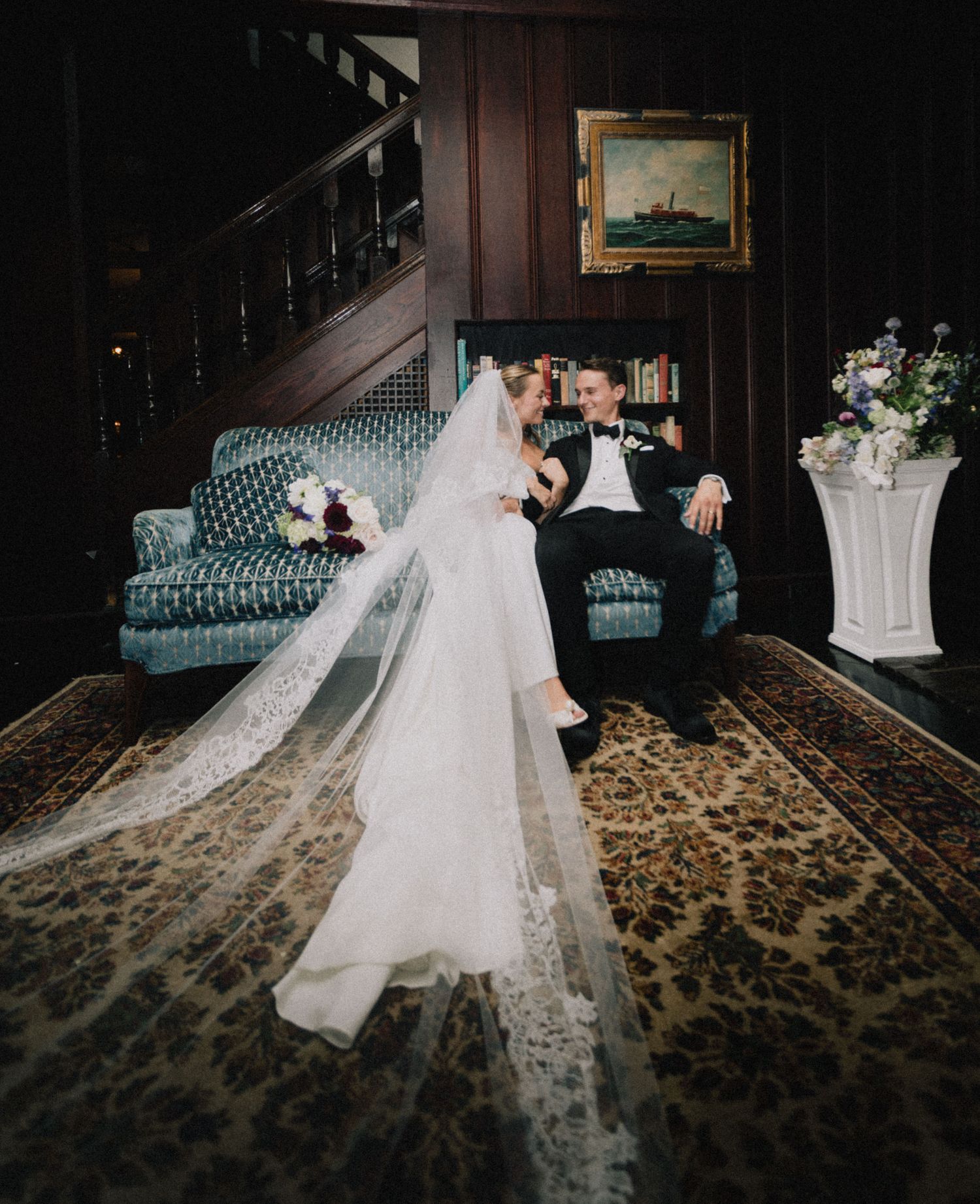 A series of romantic silhouettes show a couple embracing during a wedding photo session in a darkly lit indoor setting.