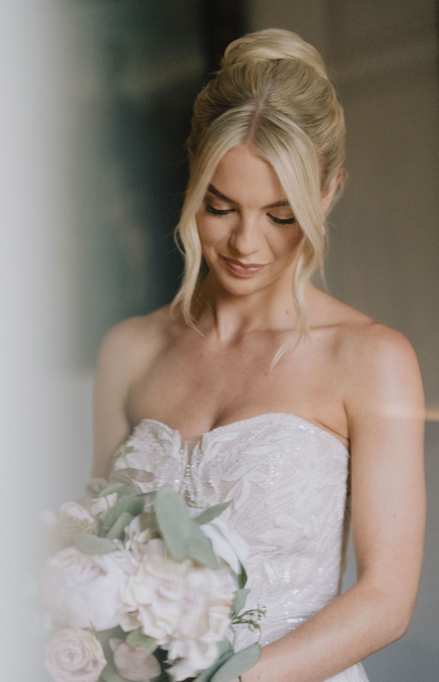Elegant bridal portrait showing lace wedding dress and soft bouquet.