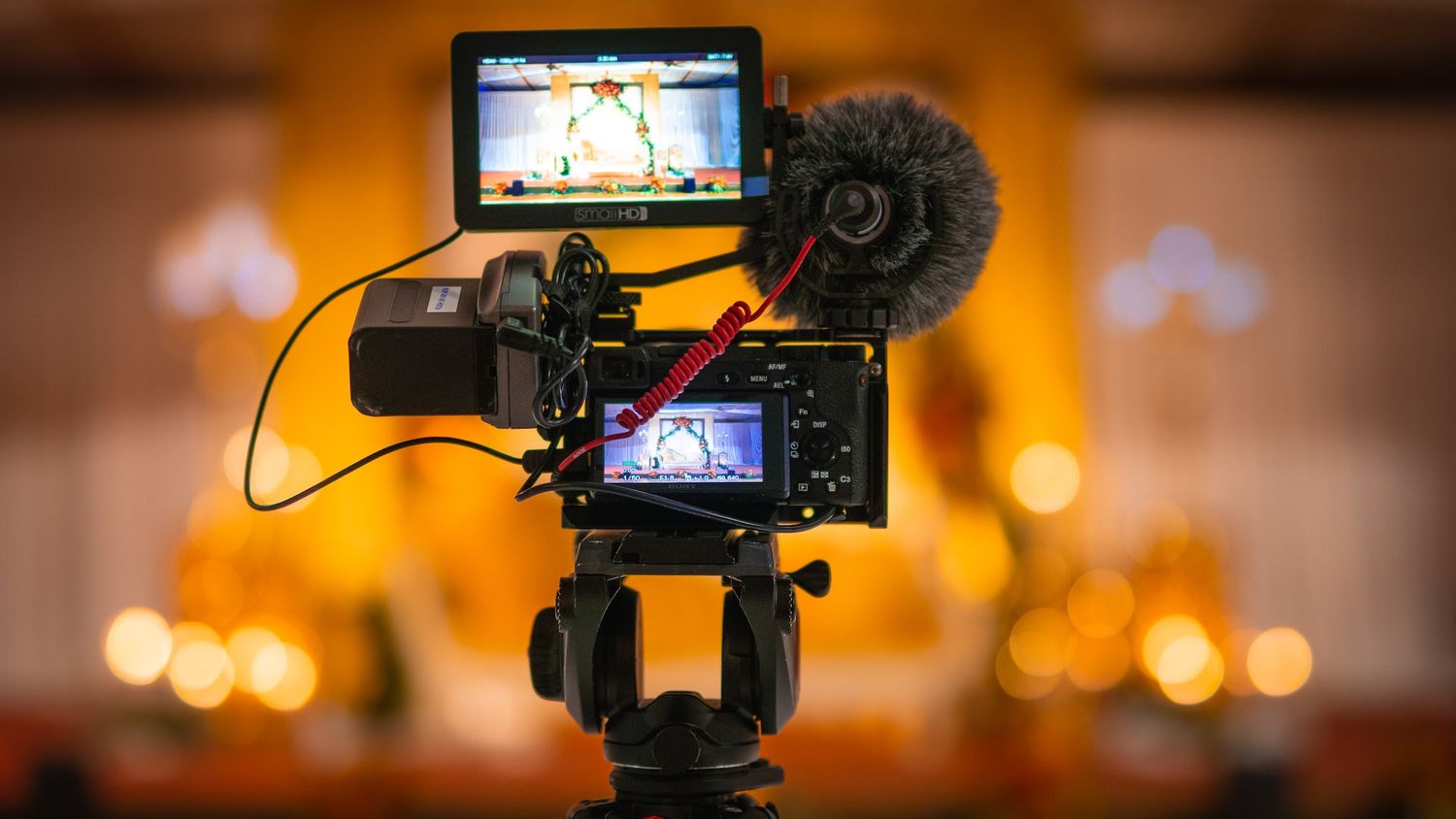 Professional camera setup with microphone and LCD screen displaying video footage.
