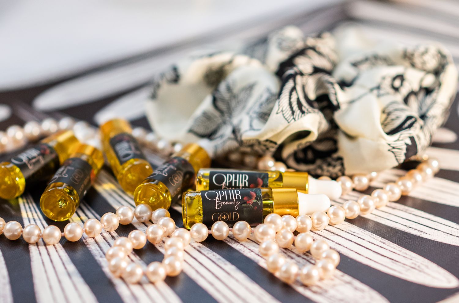 a group of ophir gold sample bottles are scattered on a bold black and white surface