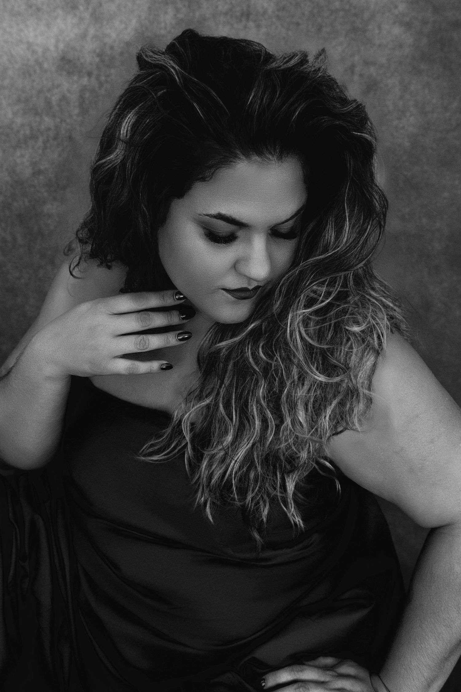 Artistic black and white portrait of someone with flowing hair in dramatic pose.