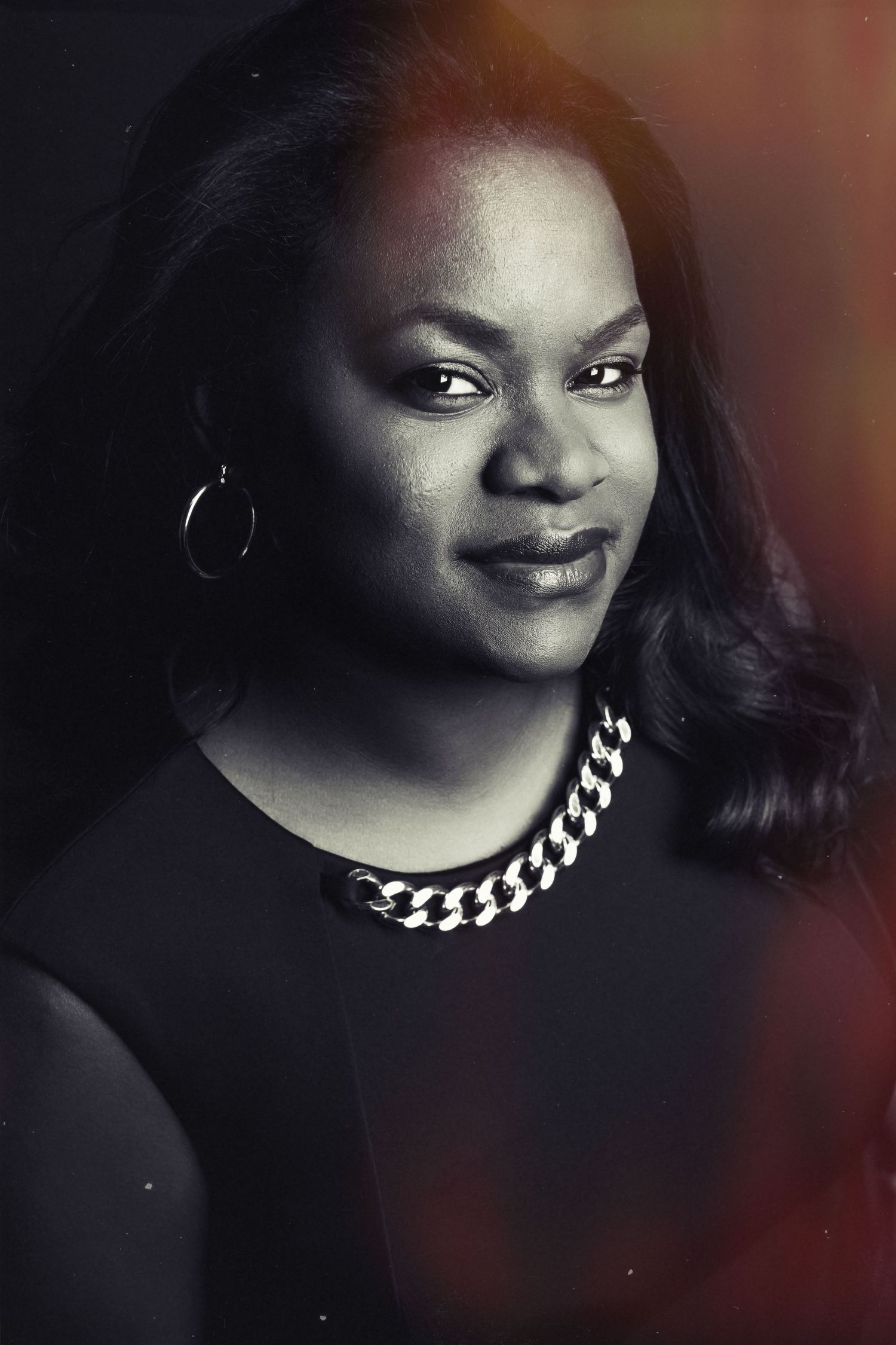 Studio portrait with dramatic lighting showing jewelry and elegant styling.