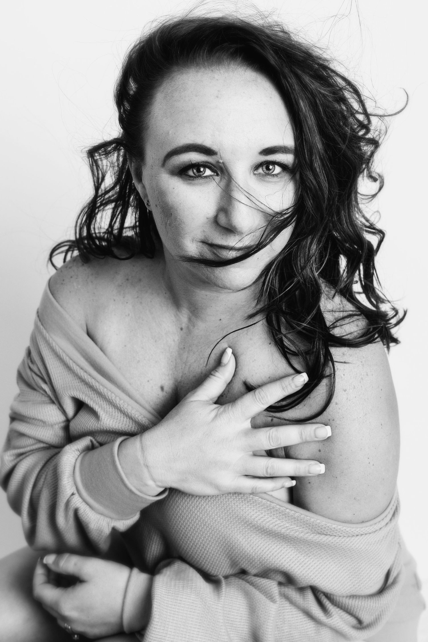 Artistic black and white portrait featuring natural expressions and an off-shoulder sweater.