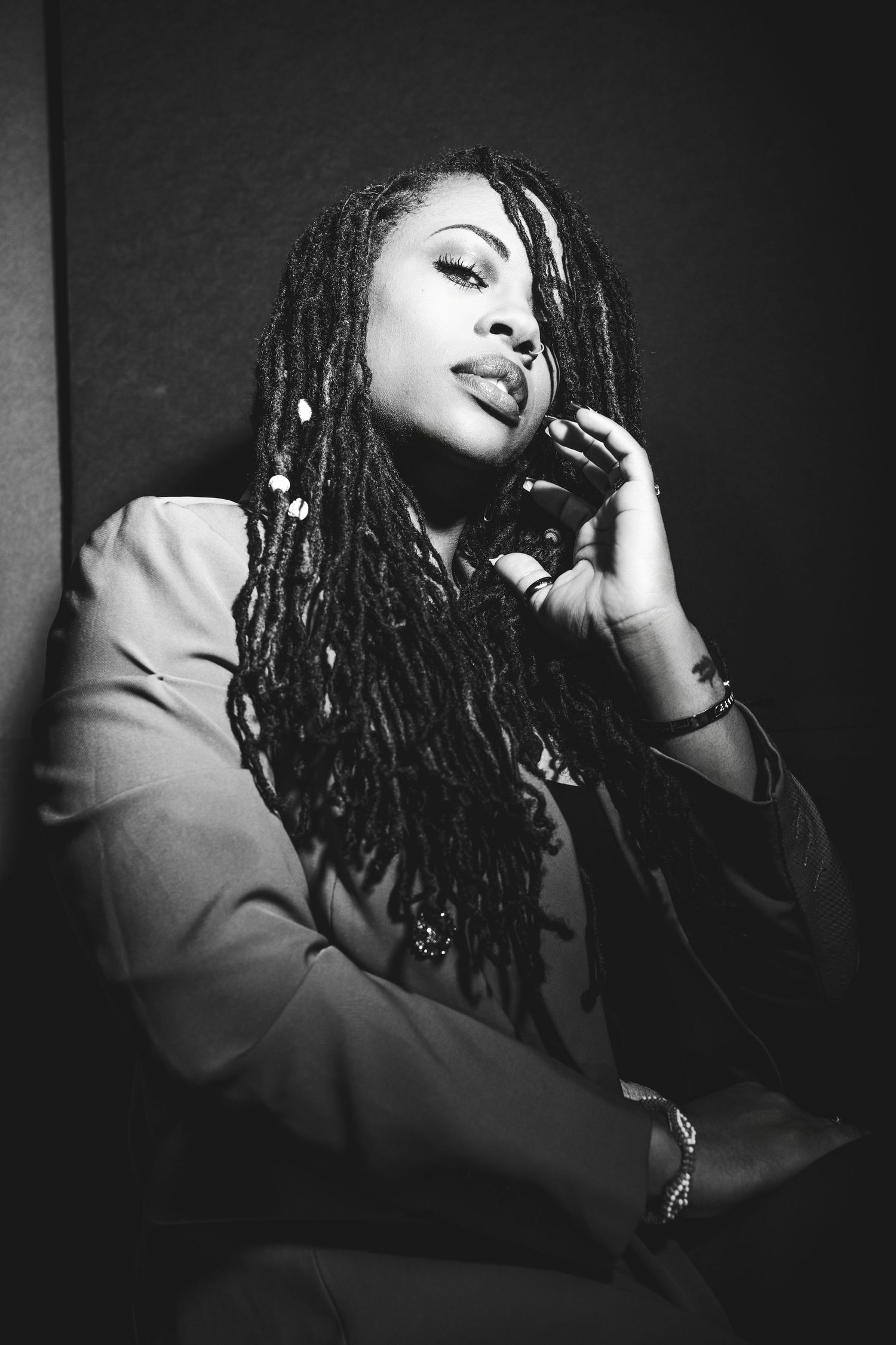 Elegant black and white portrait of woman with long braids in business attire.