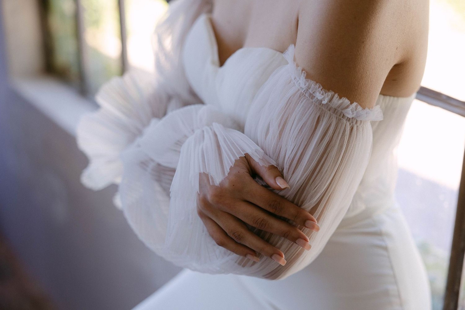 Close-up details of a delicate white wedding dress with lace embellishments.