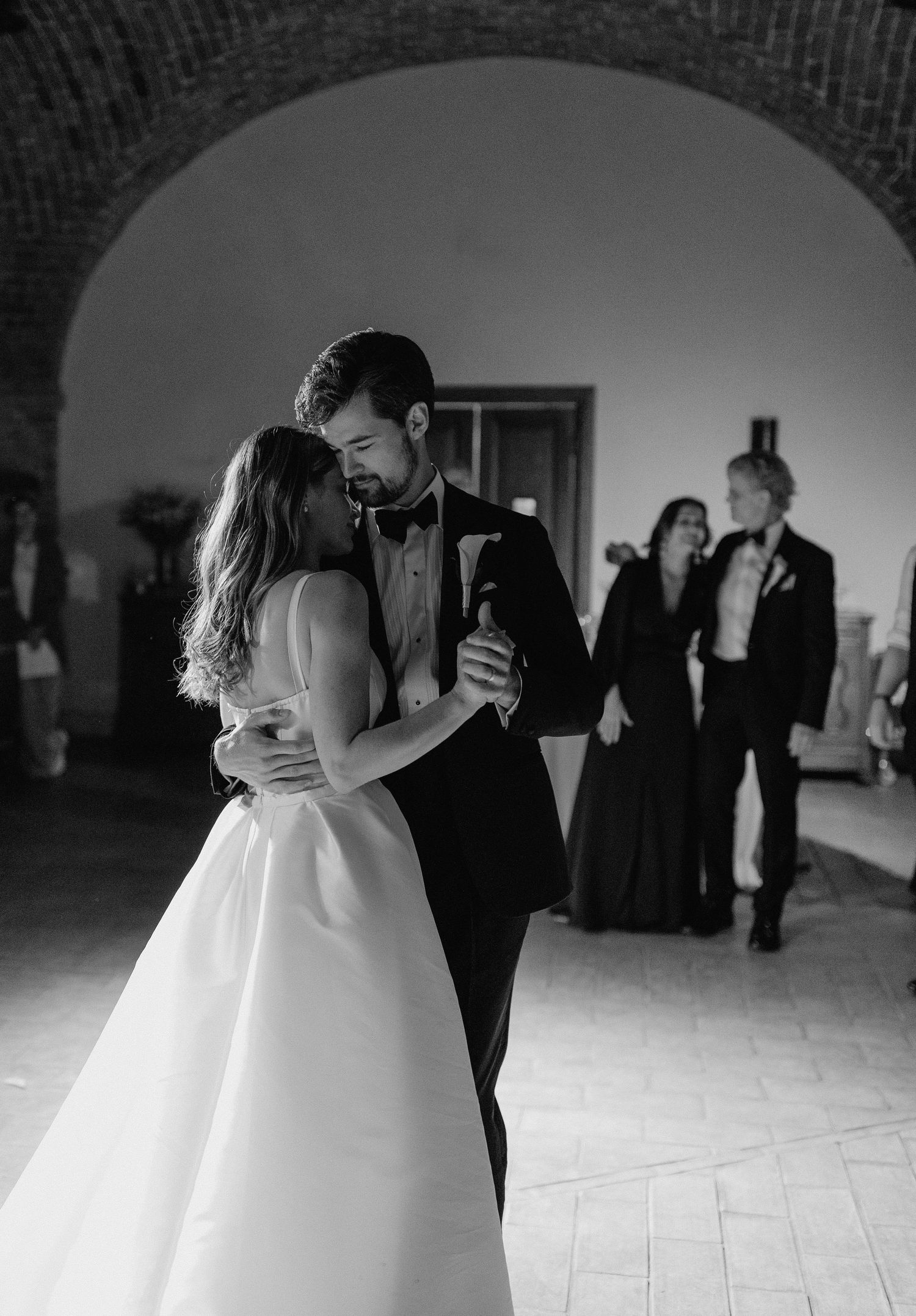A romantic first dance sequence captured in black and white photography.