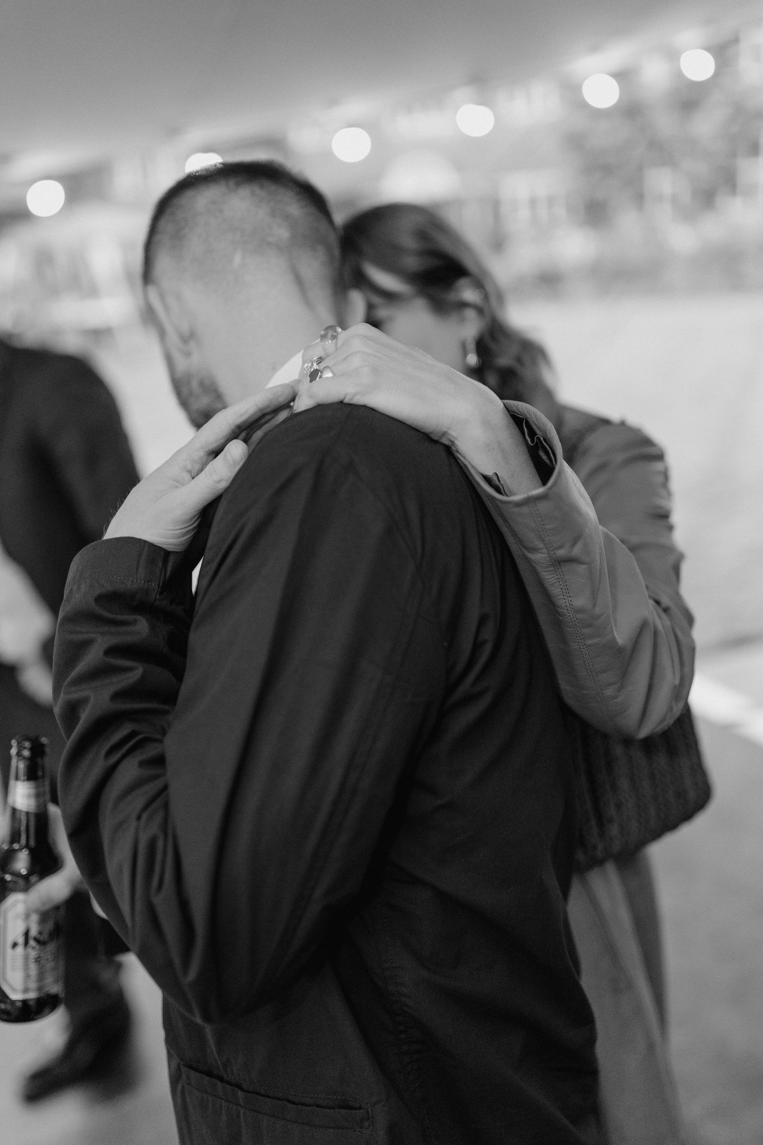A series of black and white photos showing a couple embracing in a romantic moment at a celebration.