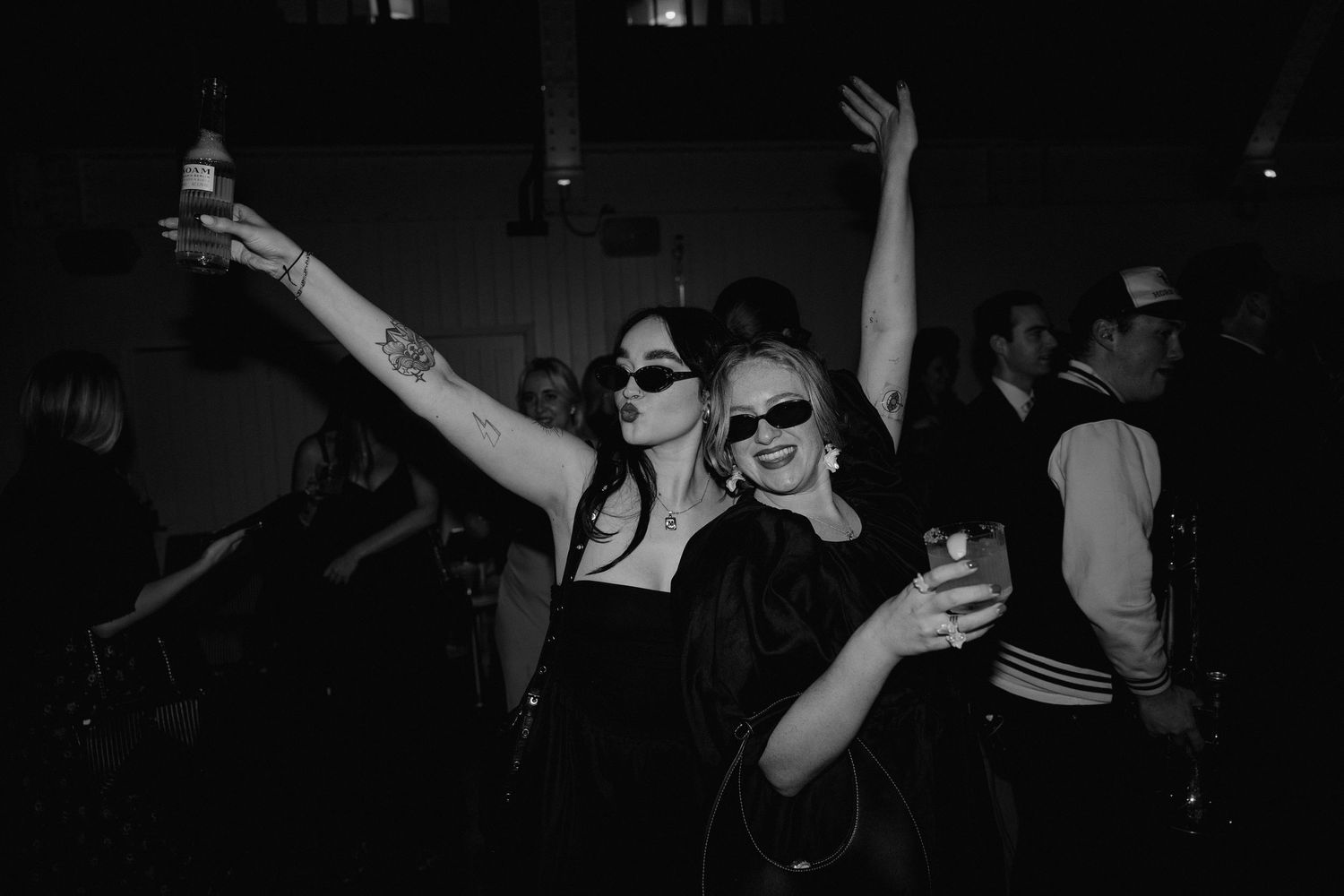 People dancing and celebrating at a dimly lit nighttime party.