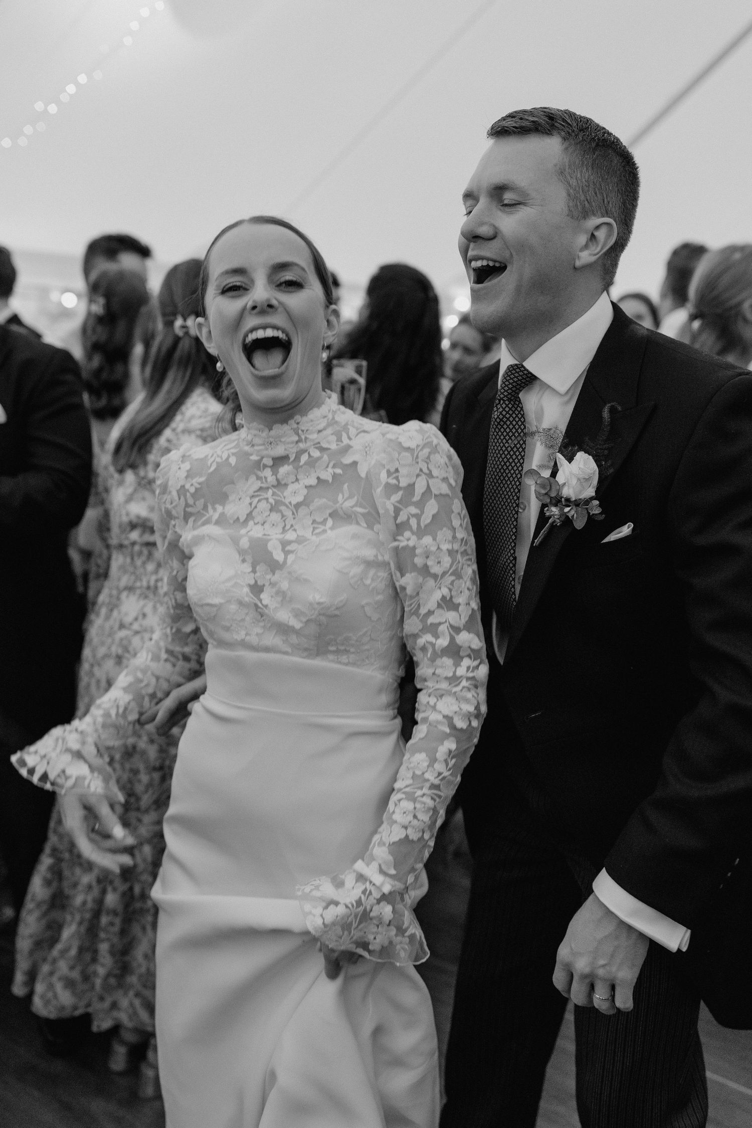 Joyful dancing and celebration during wedding reception in a tent.