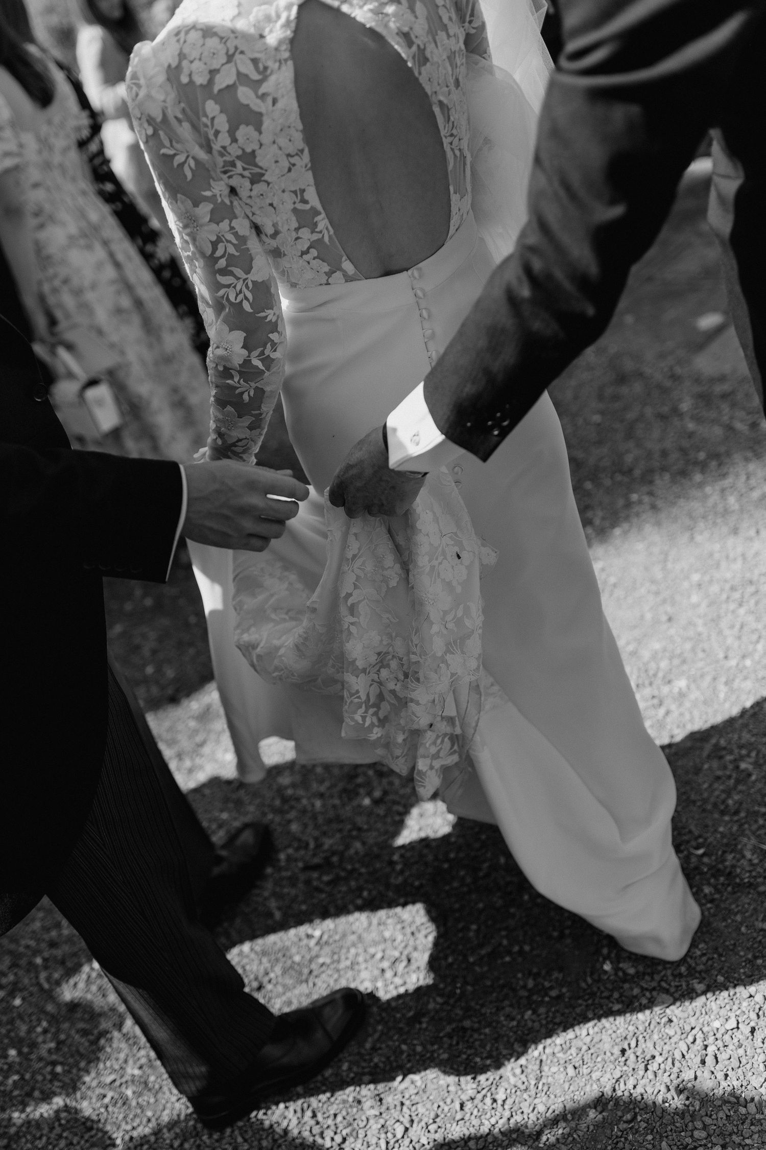 Black and white detail shot of wedding guests' feet during outdoor celebration.