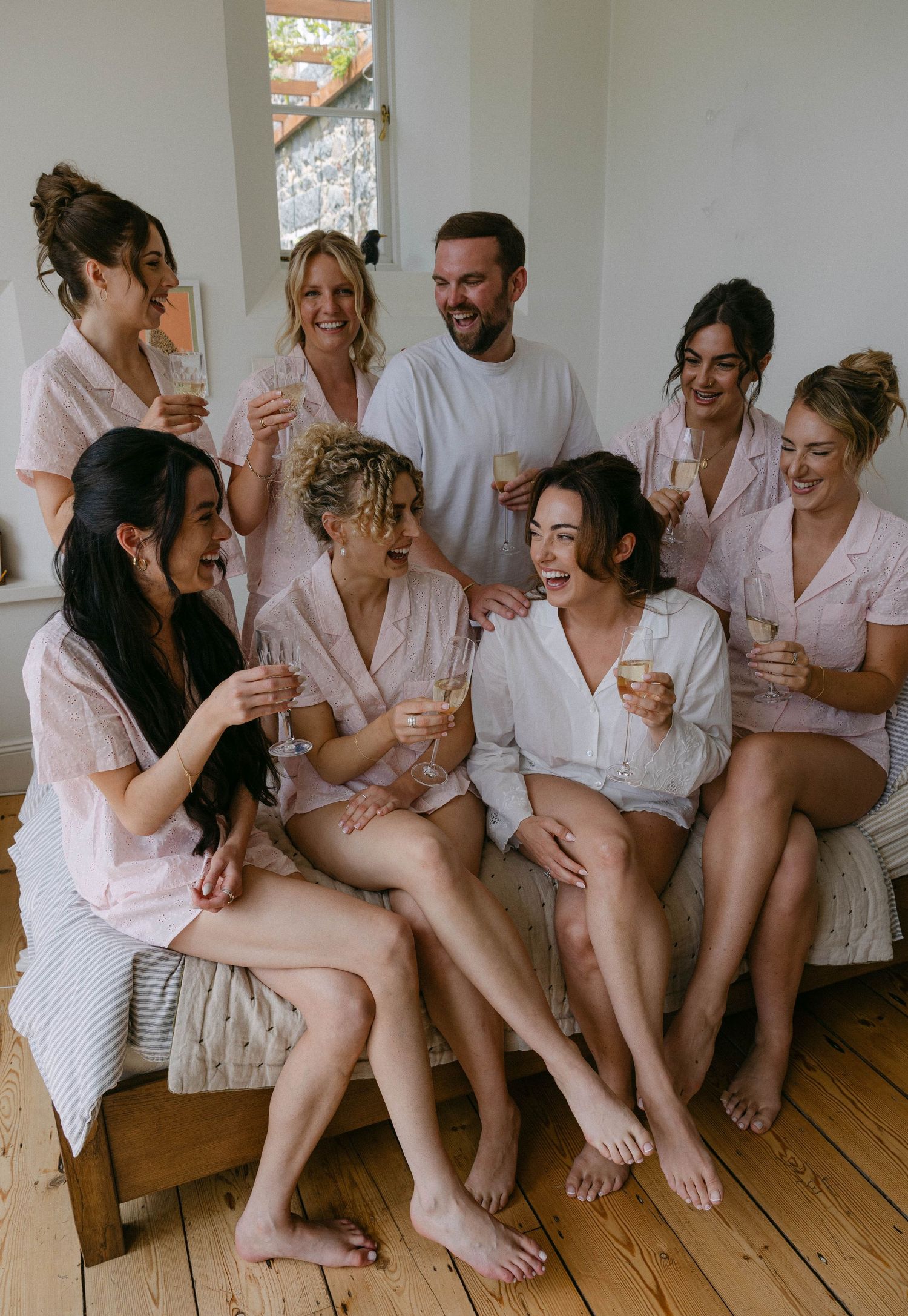 A group wearing matching pink robes sitting together on a couch.